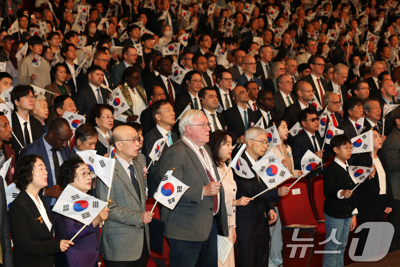 (서울=뉴스1) 이광호 기자 = 9일 오전 서울 종로구 세종문화회관에서 열린 579돌 한글날 경축식에서 참석자들이 태극기를 흔들며 한글날 노래를 부르고 있다.  2025.10.9/ …