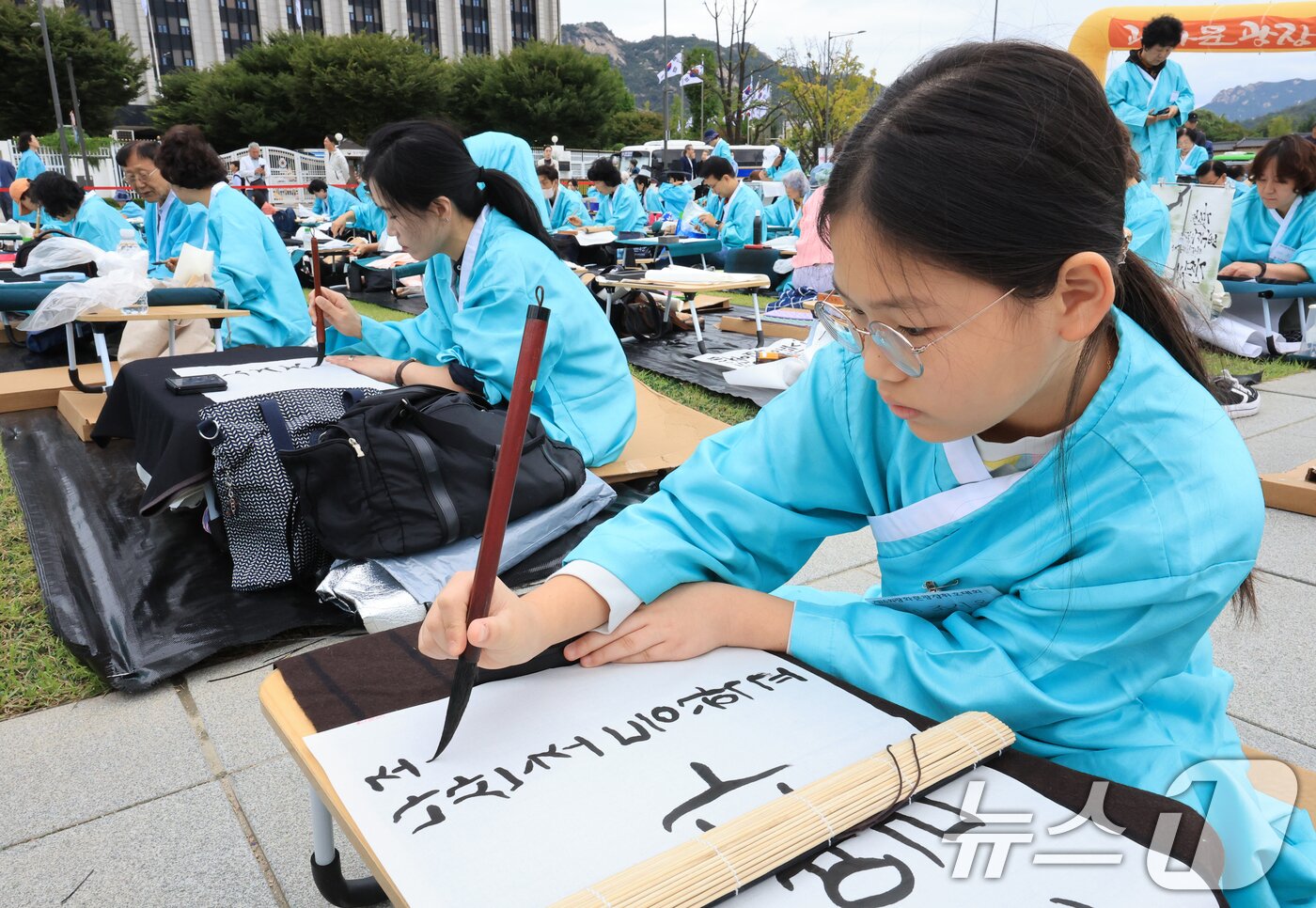 본문 이미지 - 제579돌 한글날을 맞이한 9일 서울 종로구 광화문광장에서 열린 ‘2025 제 16회 휘호대회 휘호대회‘에 참가한 학생이 한글을 쓰고 있다. 이번 대회는 총 35개국 약 400여명이 참가했다. 2025.10.9/뉴스1 ⓒ News1 이호윤 기자