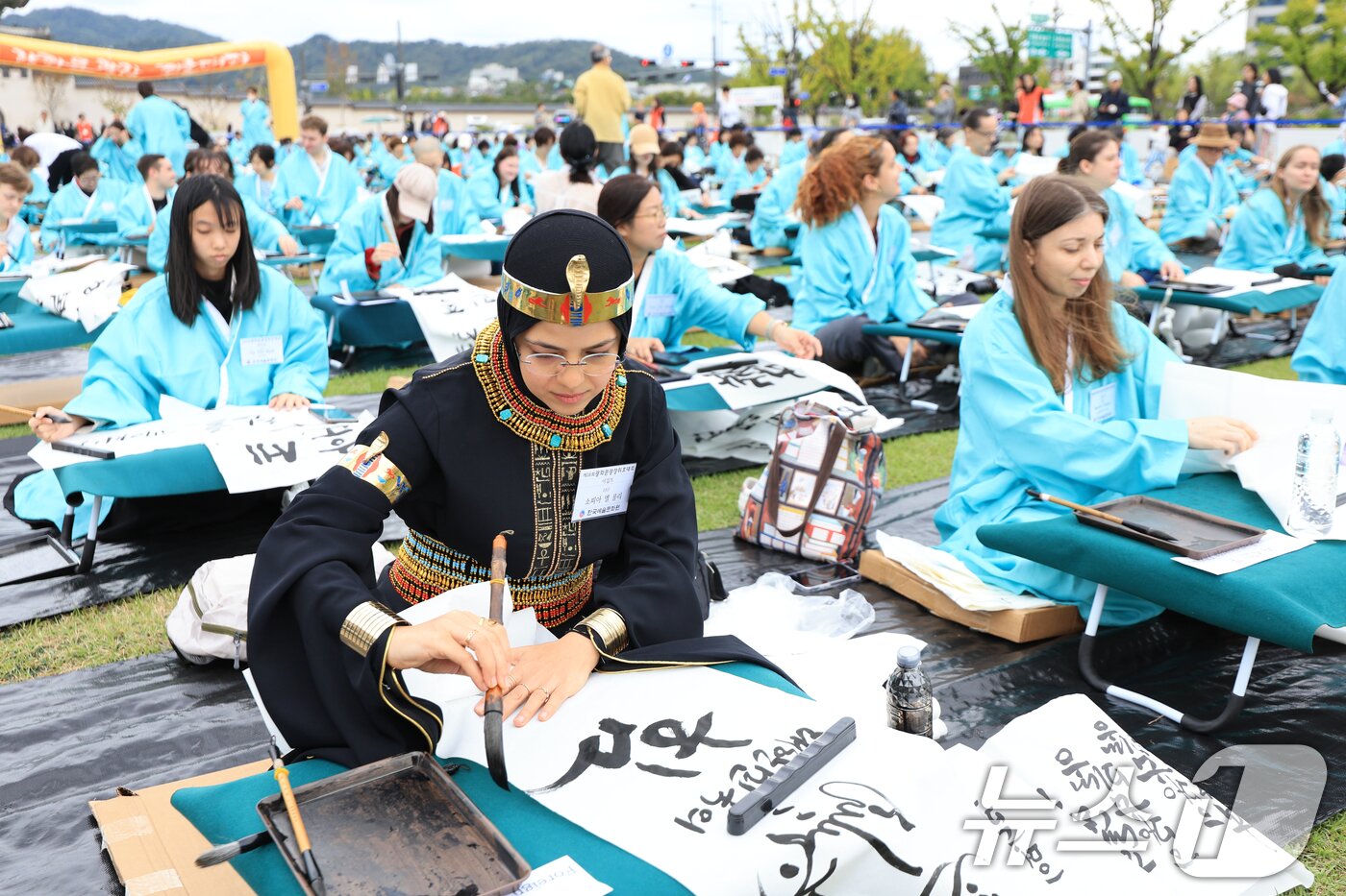 본문 이미지 - 제579돌 한글날을 맞이한 9일 서울 종로구 광화문광장에서 열린 ‘2025 제 16회 광화문광장 휘호대회‘에 참가한 외국인들이 한글을 쓰고 있다.  2025.10.9/뉴스1 ⓒ News1 이호윤 기자