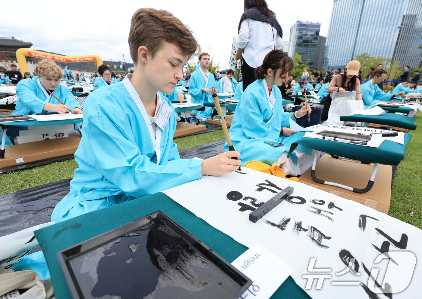 본문 이미지 - 제579돌 한글날을 맞이한 9일 서울 종로구 광화문광장에서 열린 ‘2025 제 16회 광화문광장 휘호대회‘에 참가한 외국인들이 한글을 쓰고 있다. 2025.10.9/뉴스1 ⓒ News1 이호윤 기자