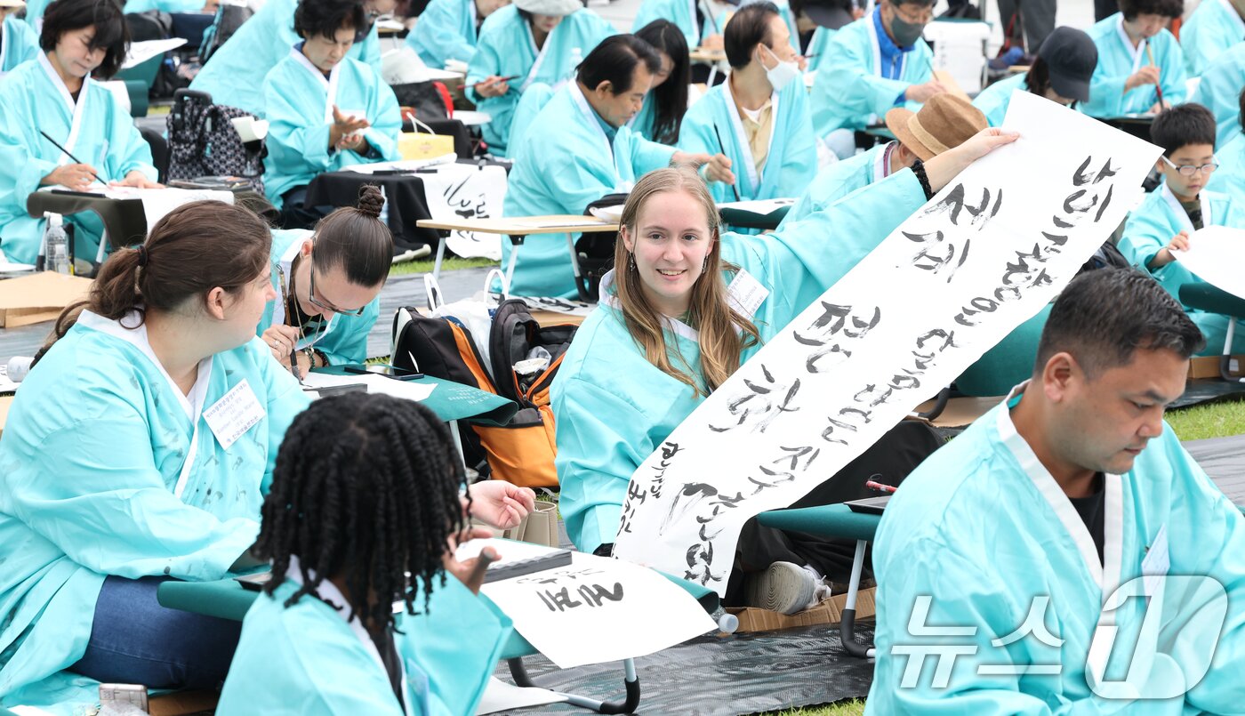 본문 이미지 - 제579돌 한글날을 맞이한 9일 서울 종로구 광화문광장에서 열린 ‘2025 제 16회 광화문광장 휘호대회‘에 참가한 외국인들이 한글을 쓰고 있다. 2025.10.9/뉴스1 ⓒ News1 이호윤 기자