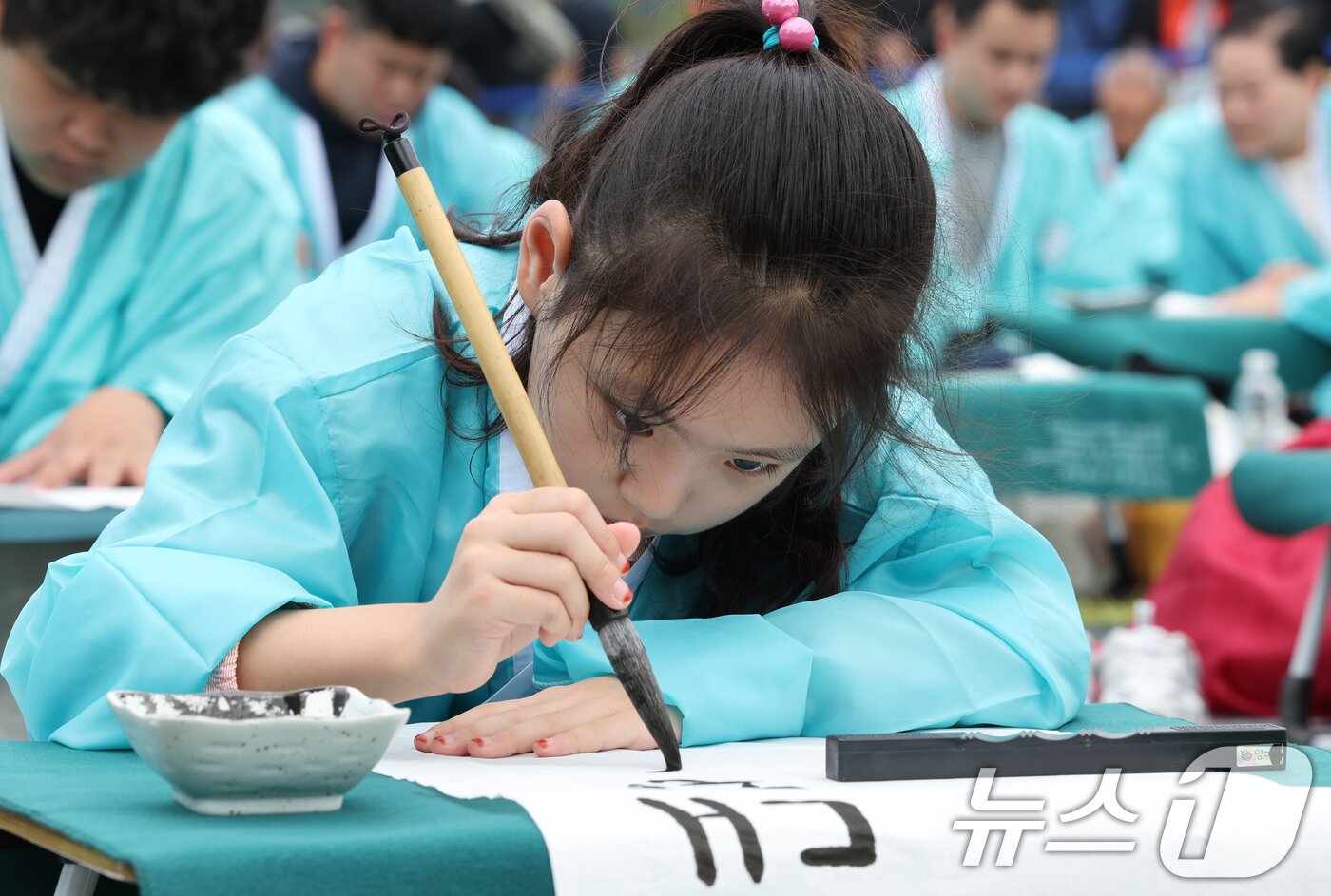 본문 이미지 - 제579돌 한글날을 맞이한 9일 서울 종로구 광화문광장에서 열린 ‘2025 제 16회 광화문광장 휘호대회‘에 참가한 학생이 한글을 쓰고 있다.  2025.10.9/뉴스1 ⓒ News1 이호윤 기자