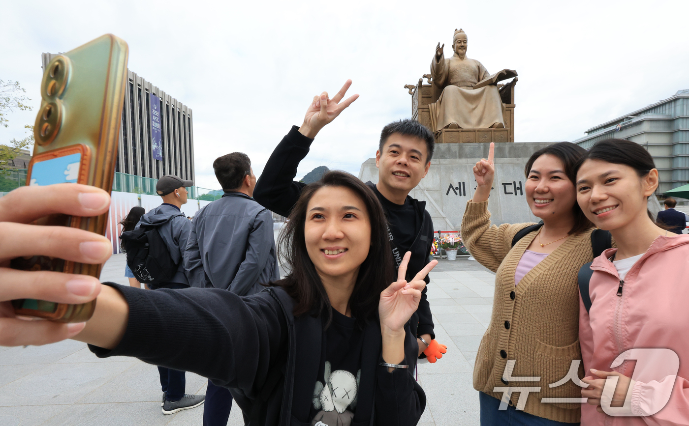 (서울=뉴스1) 이호윤 기자 = 제579돌 한글날을 맞은 9일 서울 종로구 광화문광장 세종대왕상 앞에서 열린 꽃 바치기 행사에서 중국인 관광객들이 기념촬영을 하고 있다. 이번 행사 …
