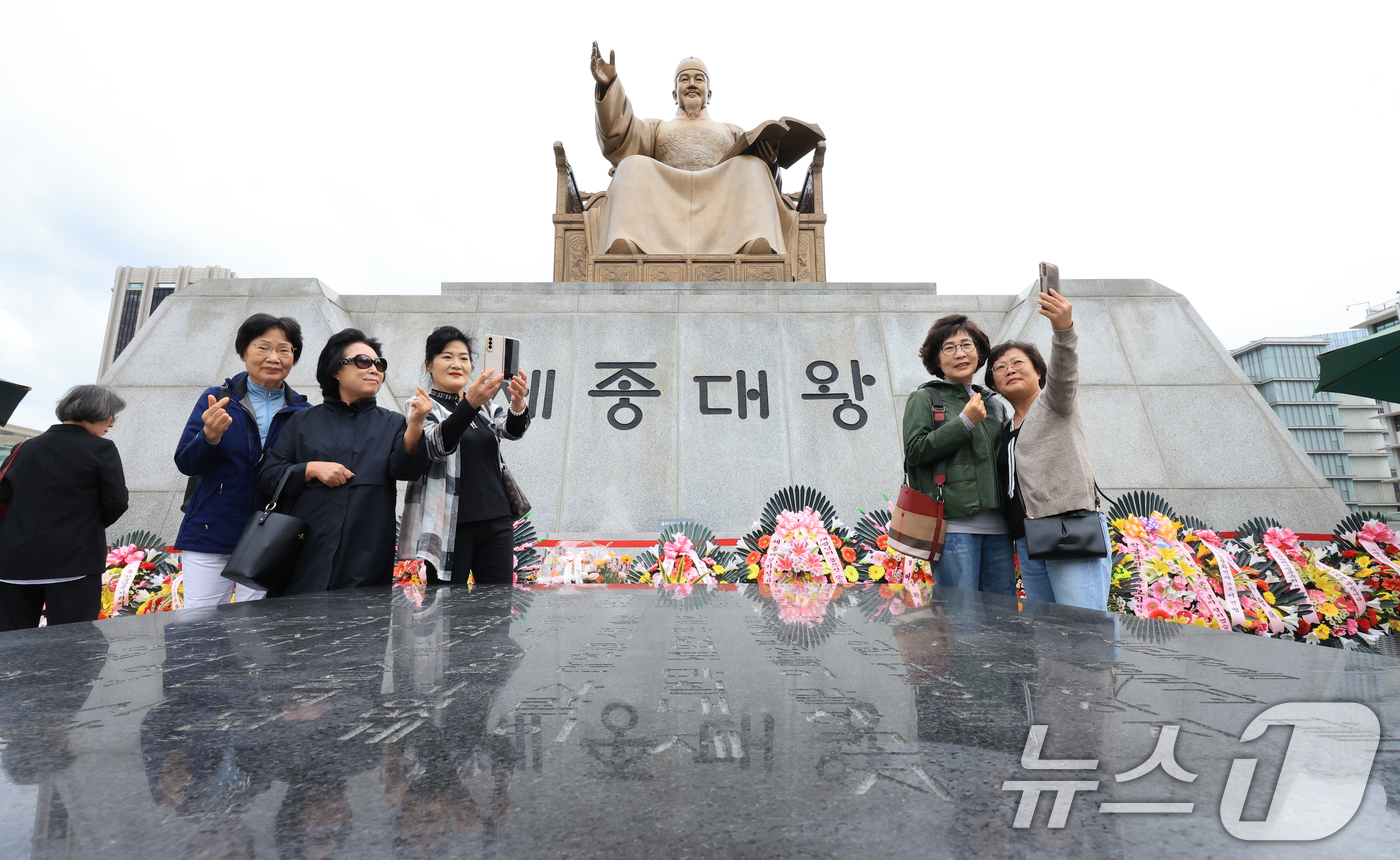 (서울=뉴스1) 이호윤 기자 = 제579돌 한글날을 맞은 9일 서울 종로구 광화문광장 세종대왕상 앞에서 열린 꽃 바치기 행사에 참여한 시민들이 기념촬영을 하고 있다. 이번 행사는 …