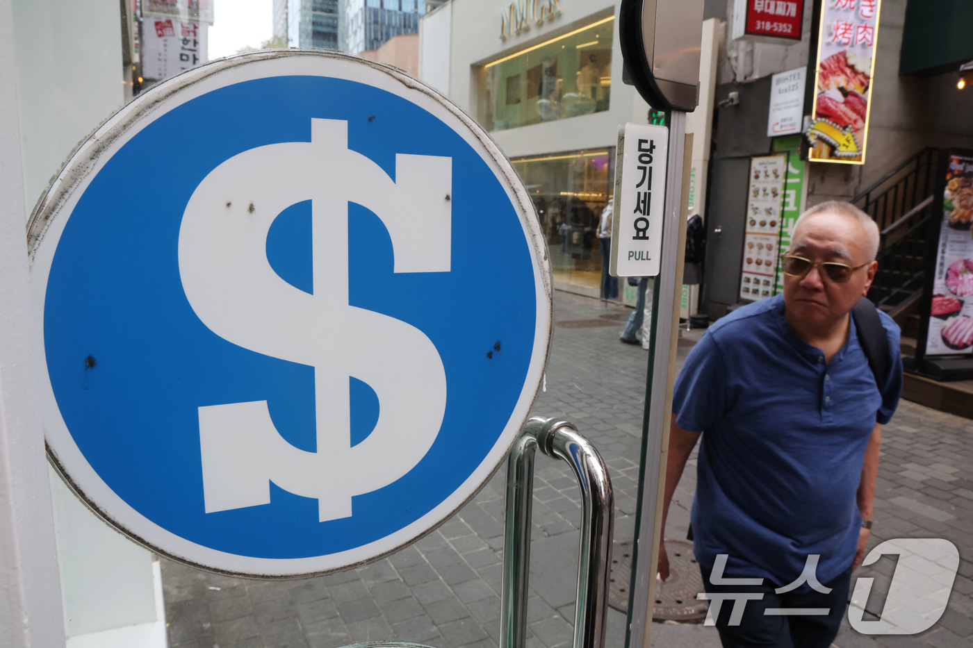(서울=뉴스1) 이광호 기자 = 한미 관세 협상 장기화로 원·달러 환율이 급등락을 반복하며 1400원 선을 이어가고 있는 9일 서울 중구 명동 환전소 앞을 관광객들이 지나가고 있다 …