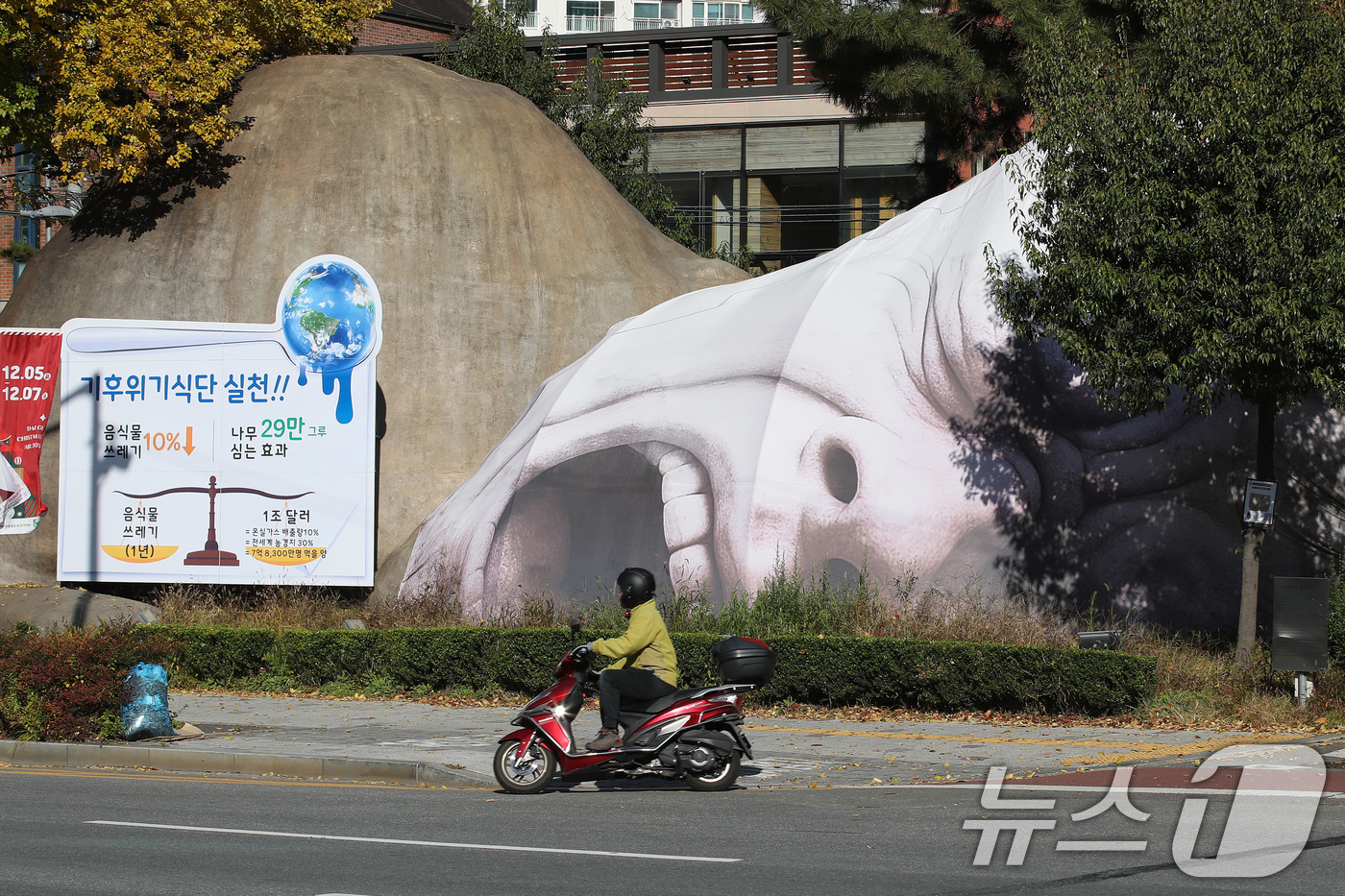 (대구=뉴스1) 공정식 기자 = 10일 대구 달서구 선사유적공원 진입로에 설치된 거대 원시인 조형물 이만옹이 '기후 위기 식단 실천 캠페인'을 펼치고 있다. 이만옹의 얼굴은 '음식 …