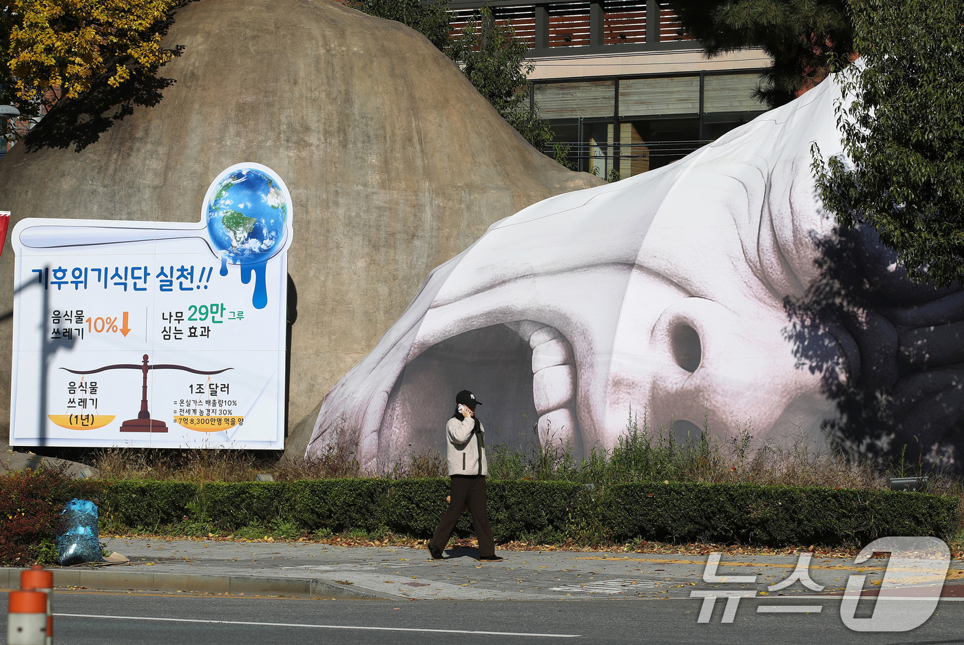 (대구=뉴스1) 공정식 기자 = 10일 대구 달서구 선사유적공원 진입로에 설치된 거대 원시인 조형물 이만옹이 '기후 위기 식단 실천 캠페인'을 펼치고 있다. 이만옹의 얼굴은 '음식 …