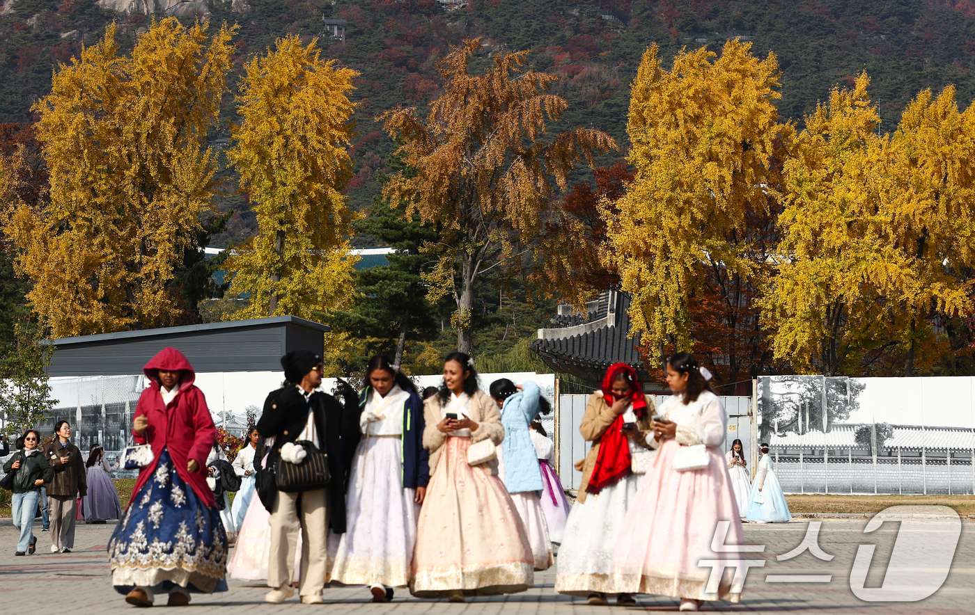 (서울=뉴스1) 김민지 기자 = 포근한 가을 날씨를 보인 11일 서울 종로구 국립고궁박물관에서 한복을 입은 관광객들 뒤로 단풍이 곱게 물들어 있다. 2025.11.11/뉴스1