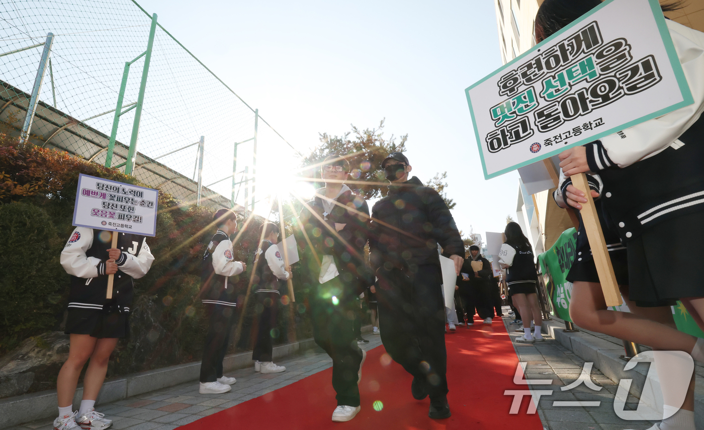 (용인=뉴스1) 김영운 기자 = 2026학년도 대학수학능력시험을 하루 앞둔 12일 경기 용인시 수지구 죽전고등학교 정문 진입로에 학생회가 준비한 '레드카펫' 길로 3학년 학생들이 …