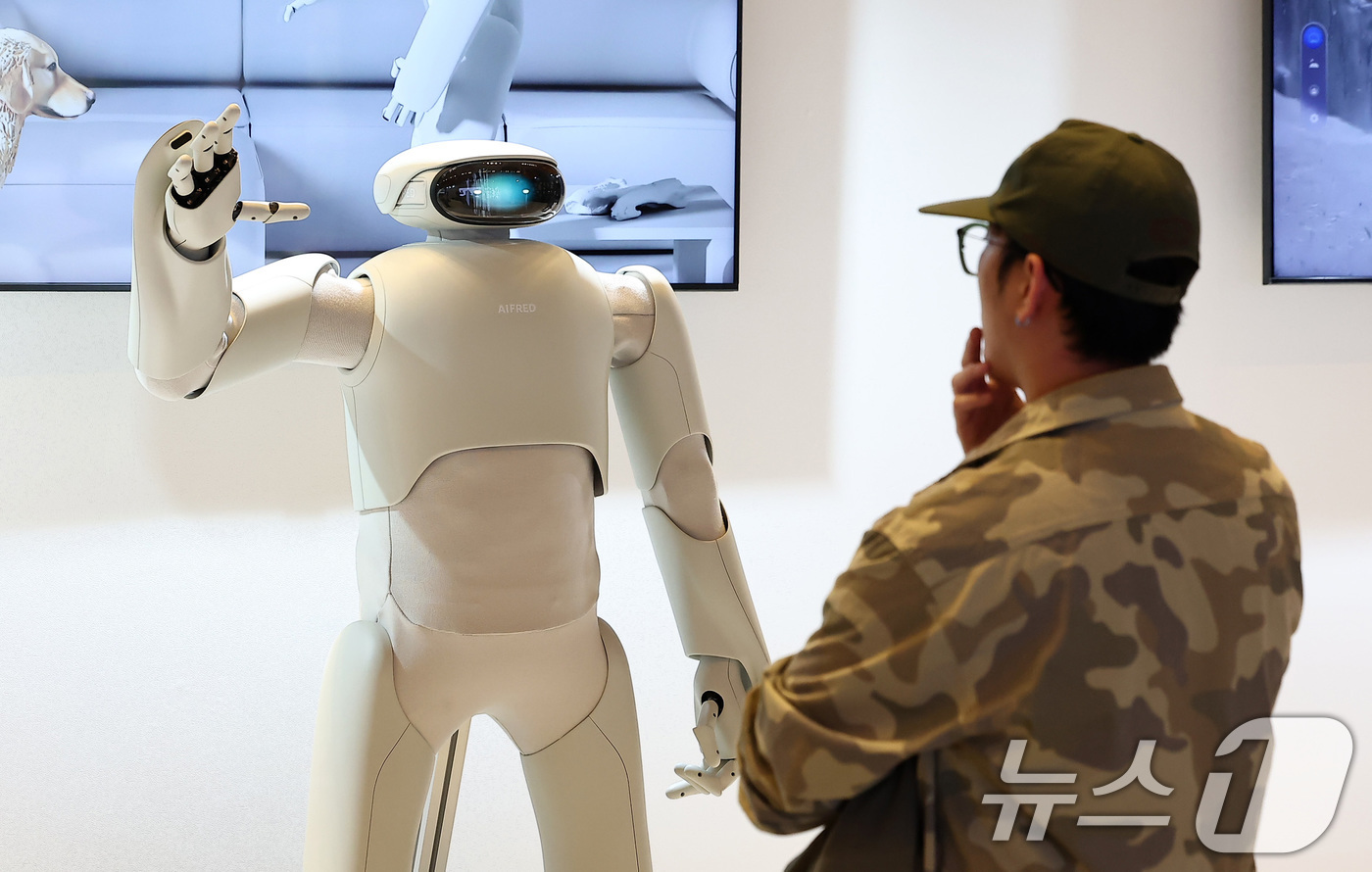 (서울=뉴스1) 김성진 기자 = 12일 서울 강남구 코엑스에서 열린 디자인코리아 2025를 찾은 한 관람객이 홍익대 산업디자인과 제품경험디자인랩 '헤이테이트'가 디자인한 AI휴머노 …