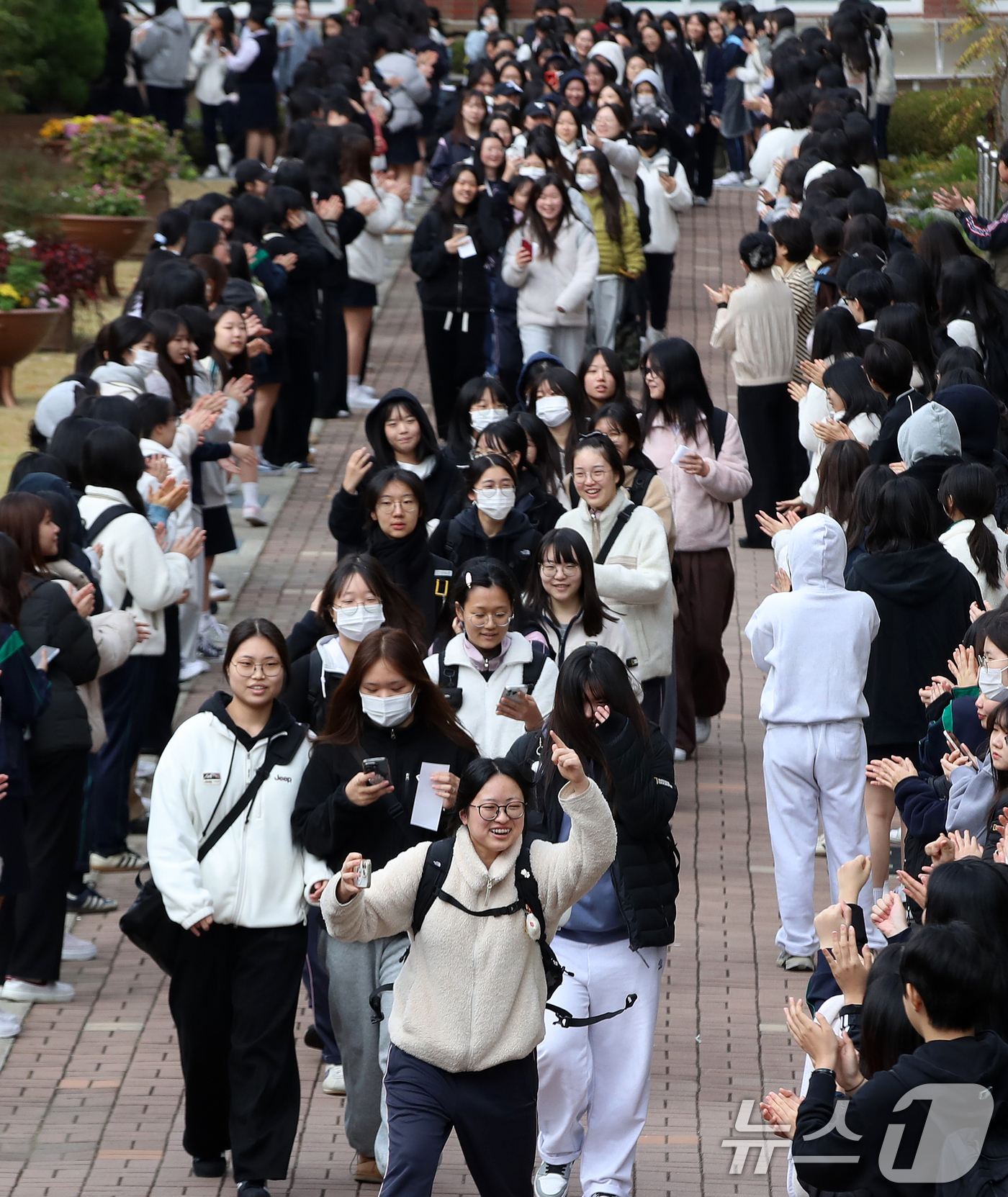 (부산=뉴스1) 윤일지 기자 = 2026학년도 대학수학능력시험 예비소집일인 12일 부산 사상구 주례여자고등학교에서 고3 수험생들이 고2 후배들의 응원을 받으며 교정을 나서고 있다. …