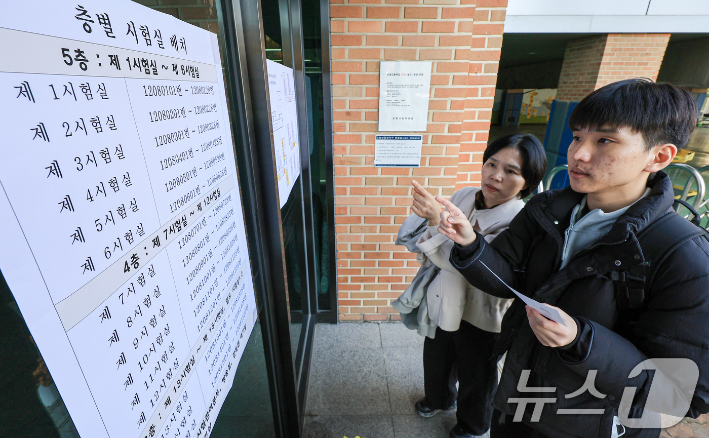 (서울=뉴스1) 이호윤 기자 = 2026학년도 대학수학능력시험을 하루 앞두고 예비 소집이 실시된 12일 서울 은평구 은평고등학교에서 학부모와 수험생이 시험실 위치를 확인하고 있다. …