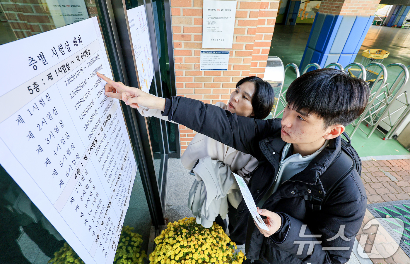 (서울=뉴스1) 이호윤 기자 = 2026학년도 대학수학능력시험을 하루 앞두고 예비 소집이 실시된 12일 서울 은평구 은평고등학교에서 수험생과 학부모가 시험실 위치를 확인하고 있다. …