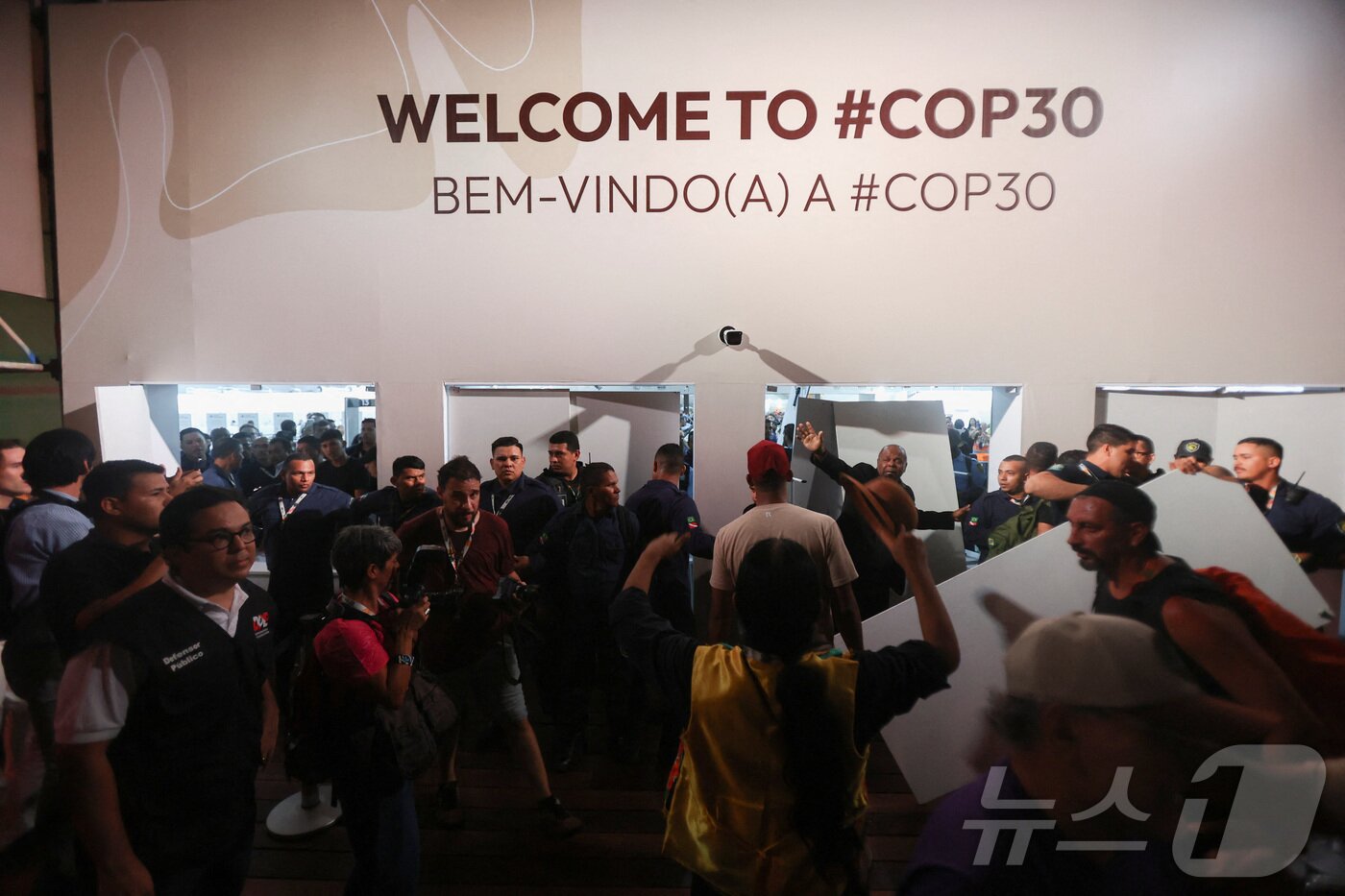 본문 이미지 - 11일&#40;현지시간&#41; 유엔기후변화협약&#40;COP30&#41;이 열리는 브라질 벨렝 행사장으로 진입하는 시위대에 맞서 보안 요원들이 입구를 지키고 있다. 2025.11.11. ⓒ 로이터=뉴스1 ⓒ News1 이정환 기자