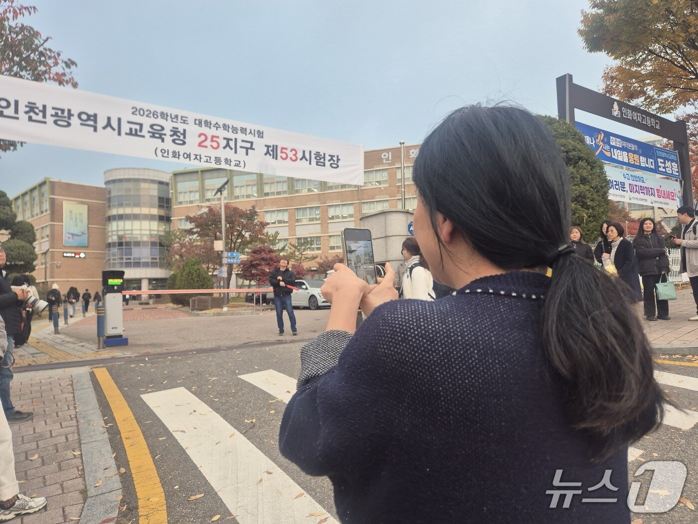 본문 이미지 -  2026학년도 대학수학능력시험일인  13일 오전 인천 인화여고에서 시험을 치르는 박소영 양&#40;19&#41;의 모습을 휴대전화로 기록하고 있는 그의 어머니/뉴스1