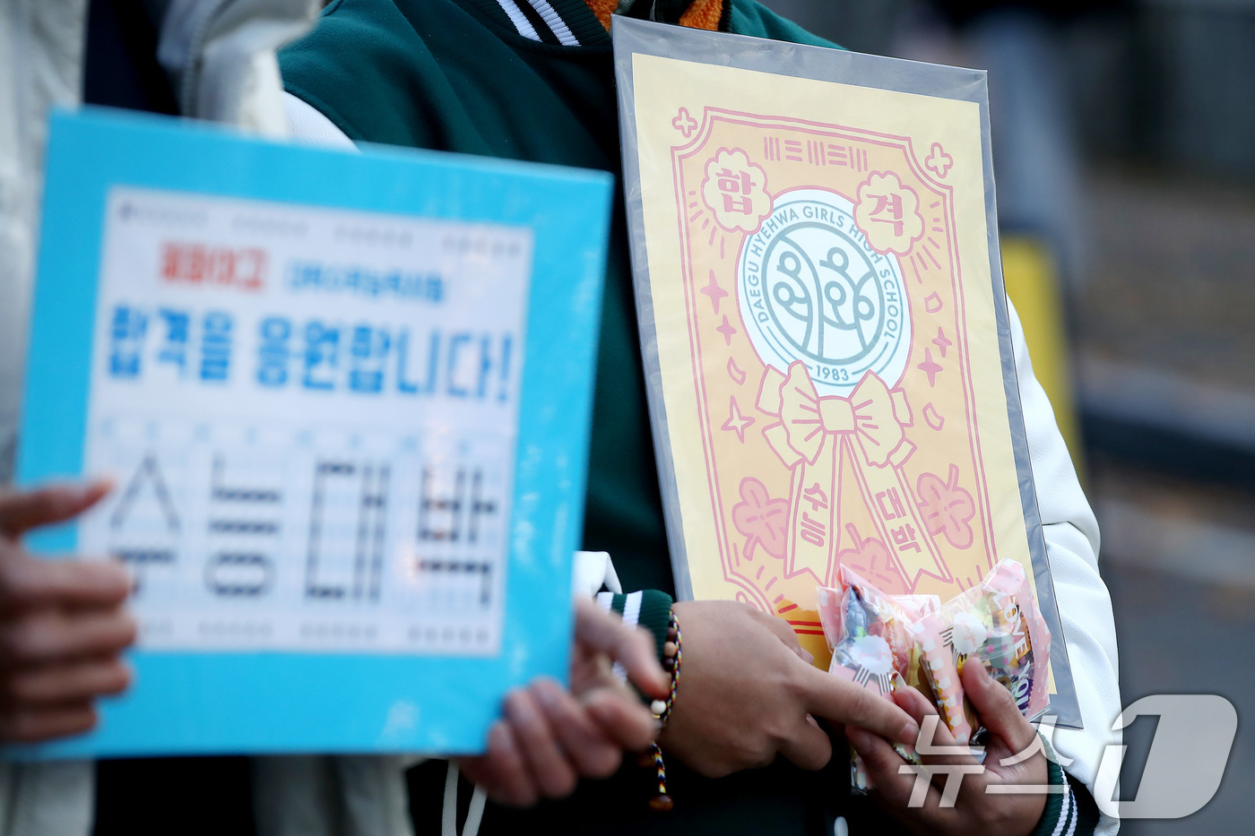 (대구=뉴스1) 공정식 기자 = 2026학년도 대학수학능력시험일인 13일 오전 대구 수성구 정화여고에 마련된 시험장 앞에서 출신학교 교사들이 간식과 부적을 준비해 수험생을 응원하고 …