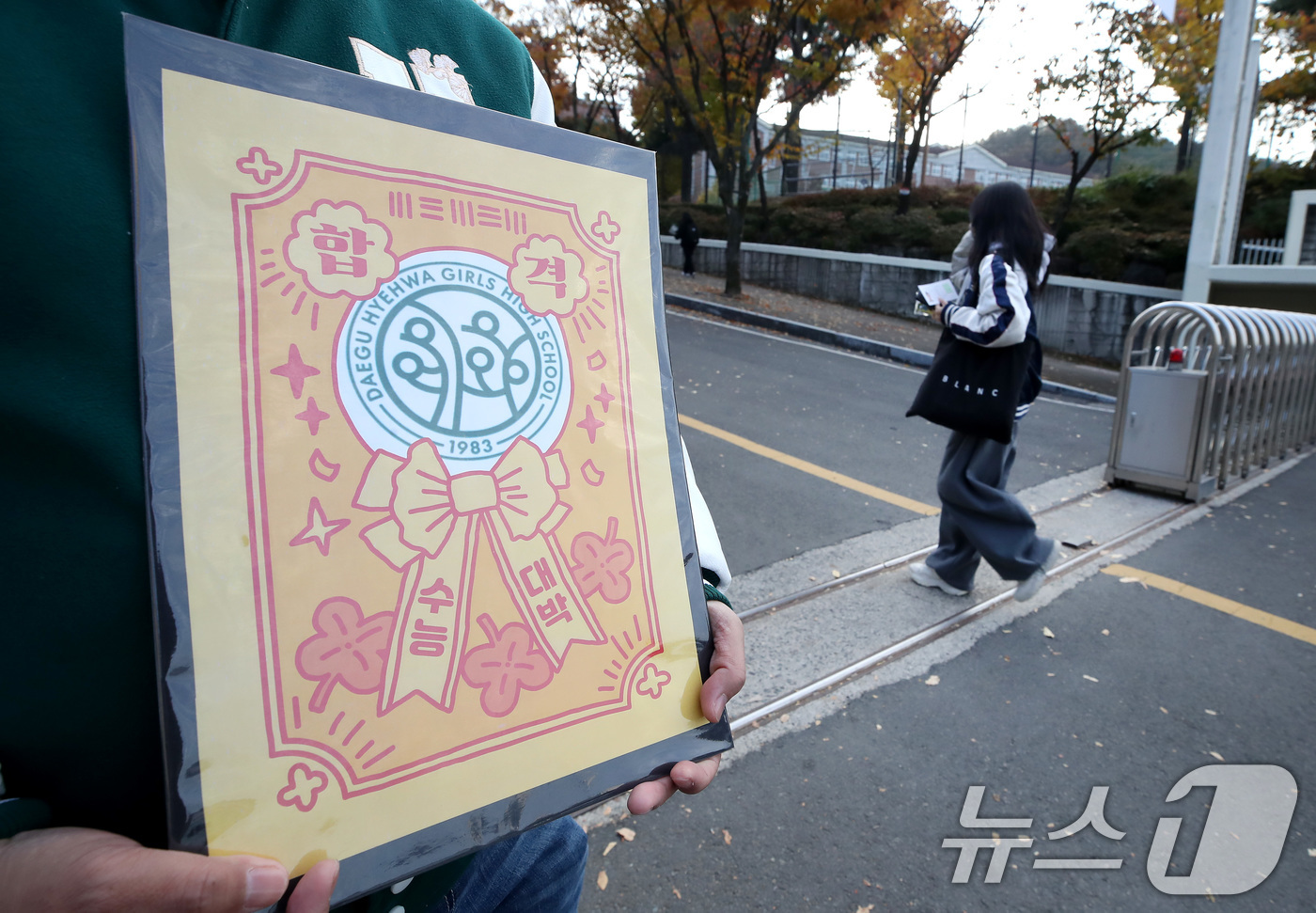 (대구=뉴스1) 공정식 기자 = 2026학년도 대학수학능력시험일인 13일 오전 대구 수성구 정화여고에 마련된 시험장 앞에서 한 교사가 부적을 손에 들고 출신학교 수험생을 응원하고 …