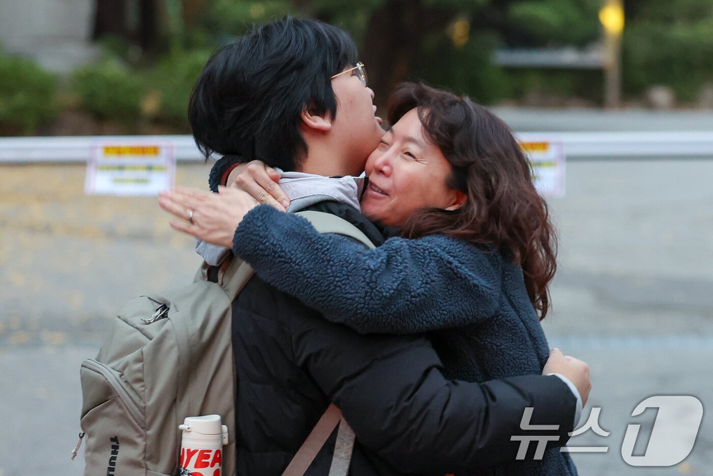 본문 이미지 - 2026학년도 대학수학능력시험일인 13일 오전 서울 종로구 경복고등학교 앞에서 한 수험생이 어머니와 포옹하고 있다. 2025.11.13/뉴스1 ⓒ News1 안은나 기자