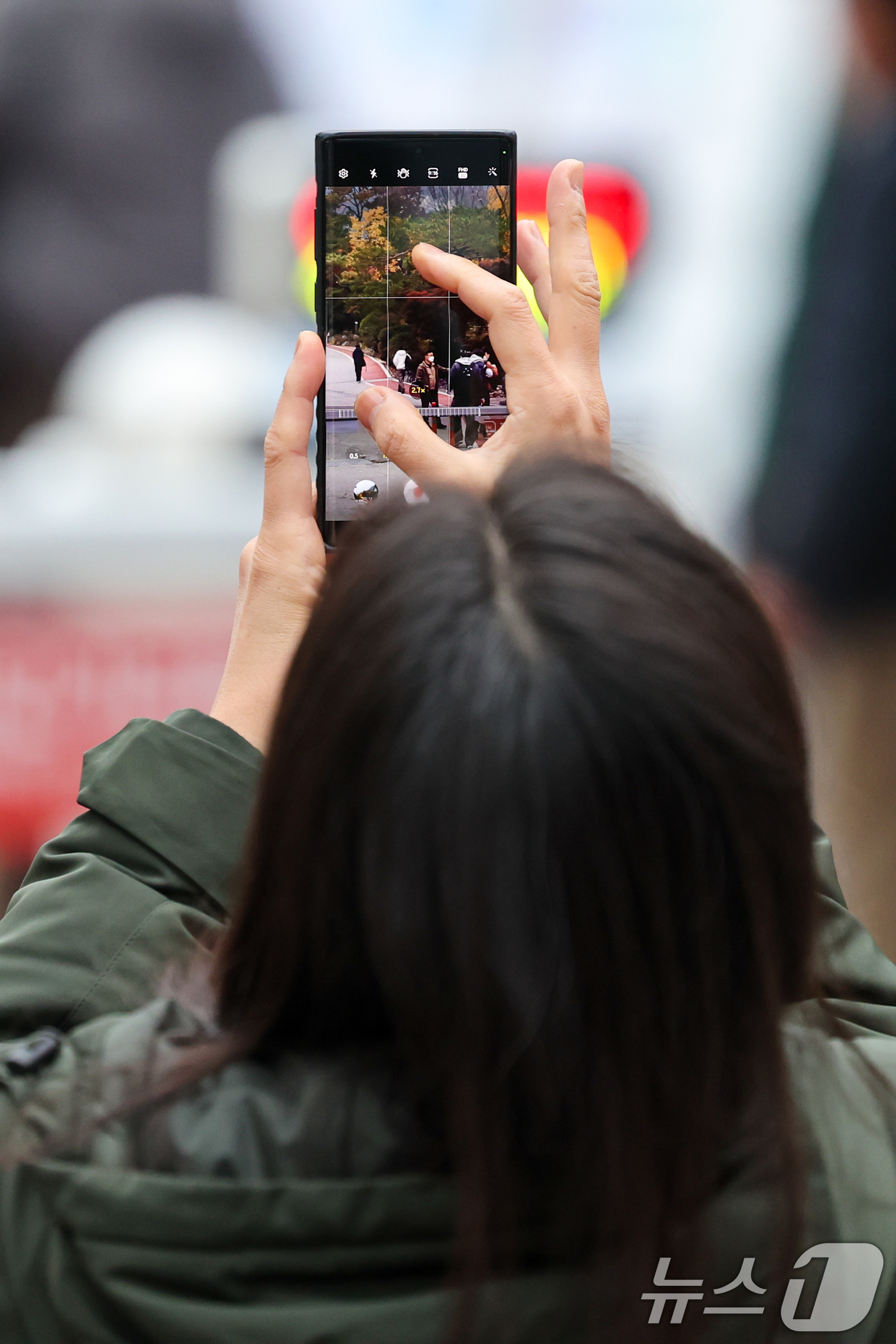(서울=뉴스1) 안은나 기자 = 2026학년도 대학수학능력시험일인 13일 오전 서울 종로구 경복고등학교 앞에서 한 어머니가 고사장으로 향하는 아들의 뒷모습을 스마트폰에 담고 있다. …