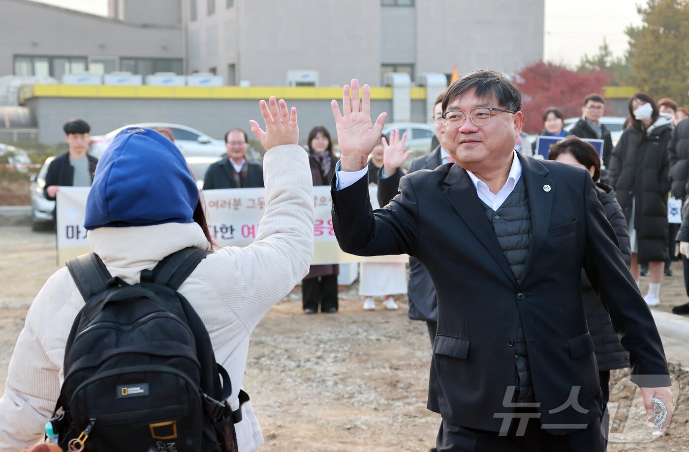 본문 이미지 - 장우성 괴산부군수가 13일 괴산고등학교 앞에서 수험생을 응원하며 하아파이브를 하고 있다.&#40;괴산군 제공, 재판매 및 DB금지&#41;/뉴스1