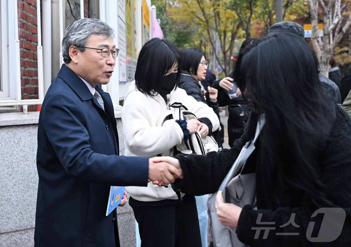 (서울=뉴스1) 사진공동취재단 = 정근식 서울시교육감이 2026학년도 대학수학능력시험일인 13일 오전 서울 광진구 광남고등학교 입구에서 수험생들을 응원하며 악수하고 있다.  202 …