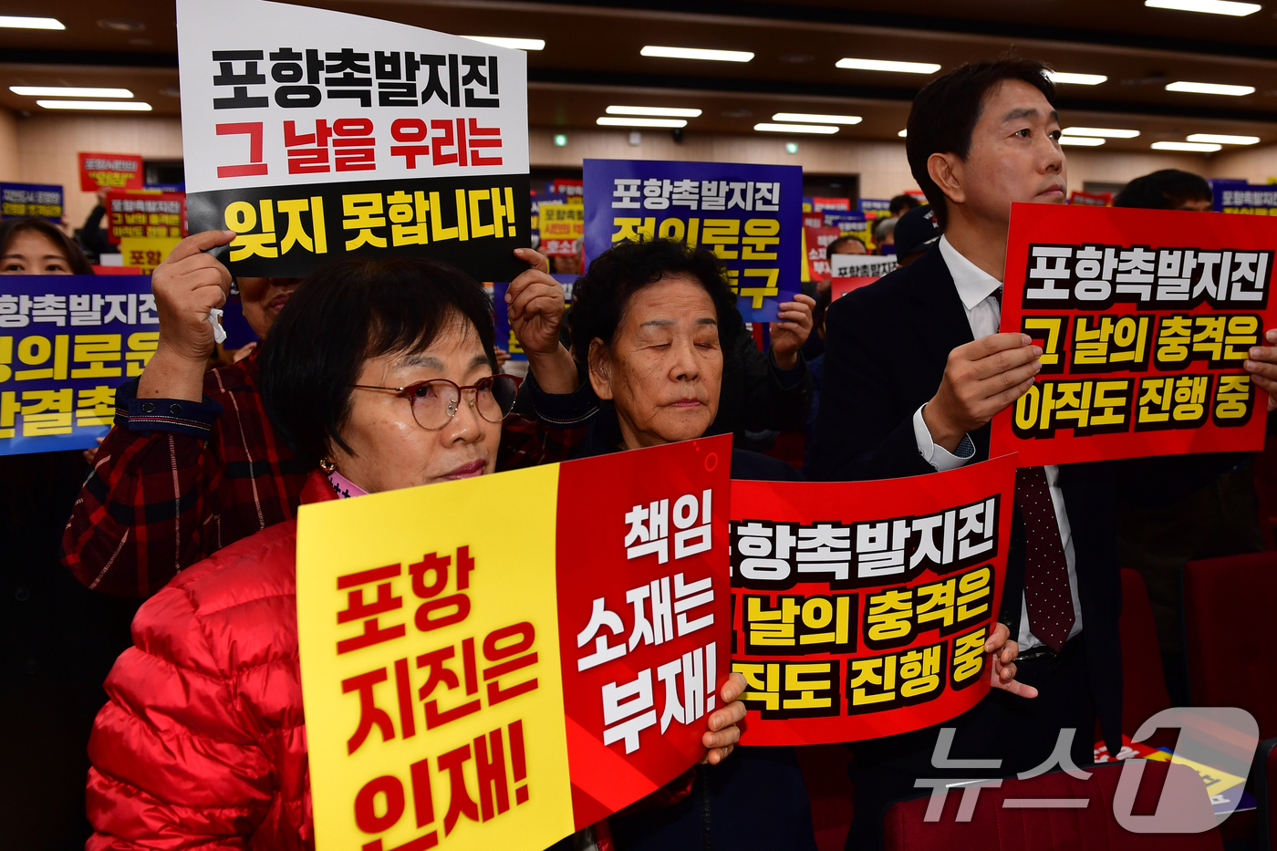 (포항=뉴스1) 최창호 기자 = 13일 경북 포항시 북구 흥해도서관에서 열린 '2025 포항지진 국제포럼'에 참석한 시민들이 정부의 책임자 처벌과 정신적피해 보상을 요구하며 피켓팅 …