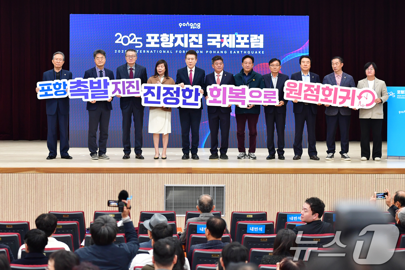 (포항=뉴스1) 최창호 기자 = 이강덕 경북 포항시장 등 내빈들이 13일 경북 포항시 북구 흥해도서관에서 열린 '2025 포항지진 국제포럼'에 앞서 피켓팅 퍼포먼스를 펼치고 있다. …