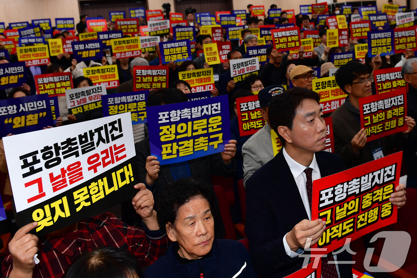 (포항=뉴스1) 최창호 기자 = 13일 경북 포항시 북구 흥해도서관에서 열린 '2025 포항지진 국제포럼'에 참석한 시민들이 정부의 책임자 처벌과 정신적피해 보상을 요구하며 피켓팅 …