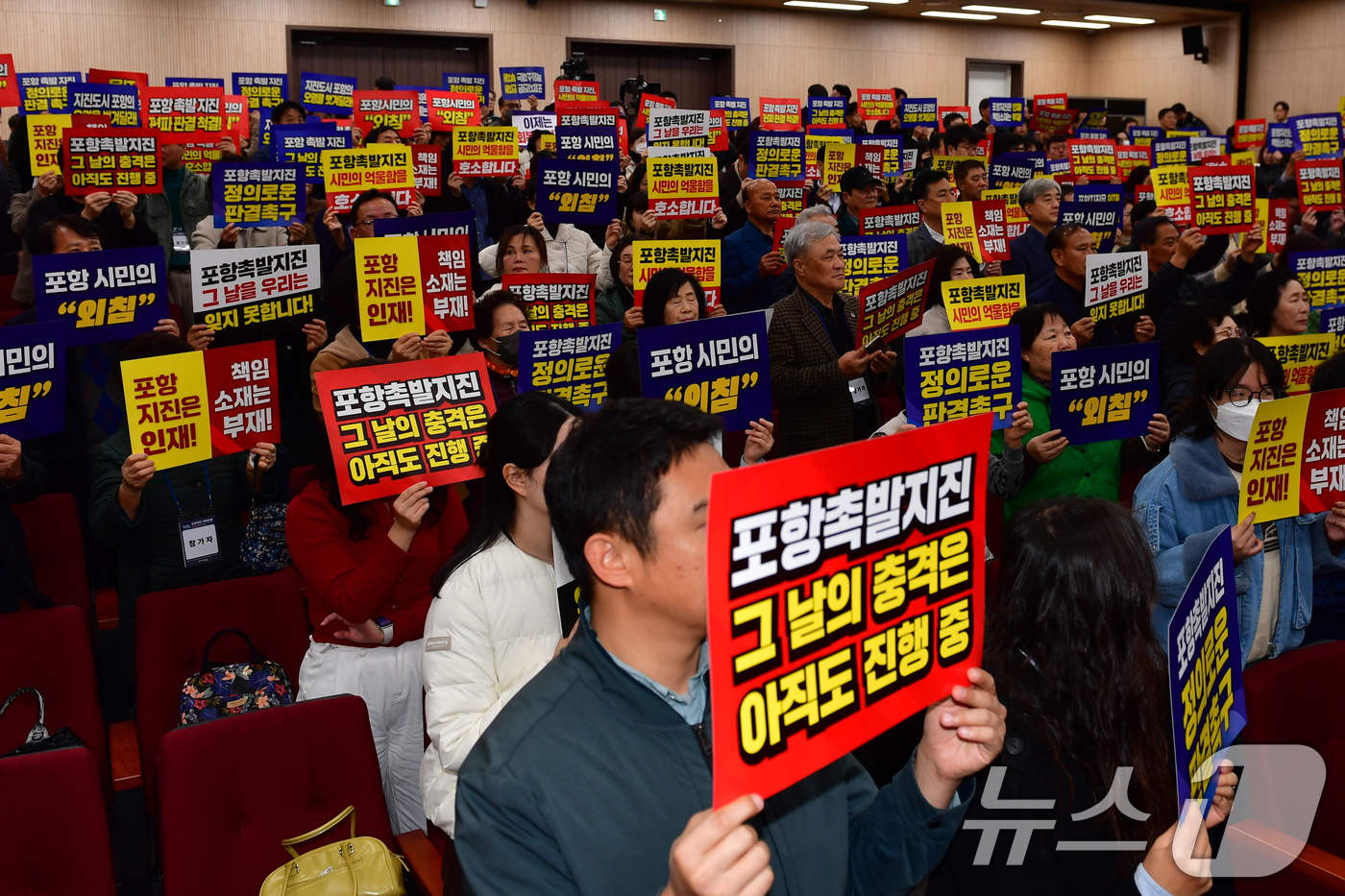 (포항=뉴스1) 최창호 기자 = 13일 경북 포항시 북구 흥해도서관에서 열린 '2025 포항지진 국제포럼'에 참석한 시민들이 정부의 책임자 처벌과 정신적피해 보상을 요구하며 피켓팅 …
