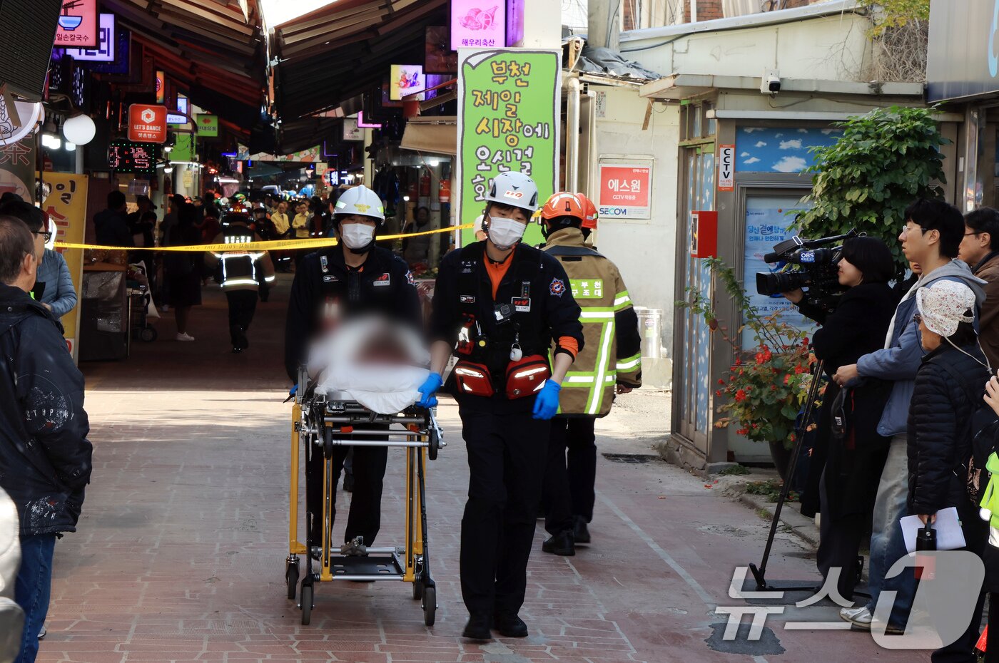 본문 이미지 - 13일 경기 부천 오정구 원종동 제일시장에서 A 씨가 몰던 1톤 트럭이 돌진하는 사고가 발생해 소방 관계자들이 피해입은 시민들을 구조하고 있다. 2025.11.13/뉴스1 ⓒ News1 이호윤 기자