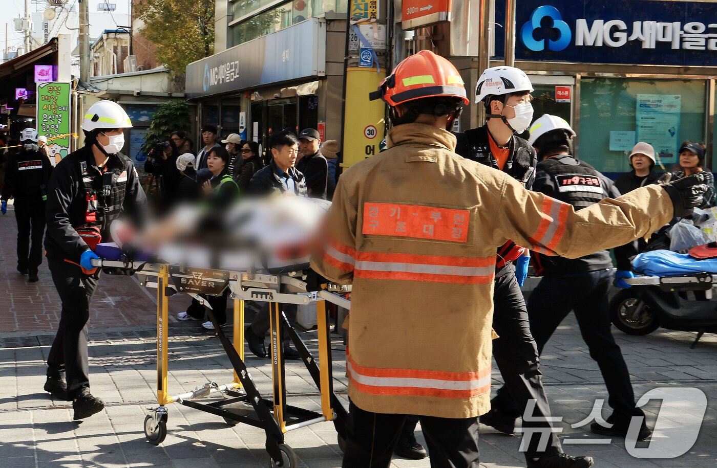 본문 이미지 - 13일 경기 부천 오정구 원종동 제일시장에서 A 씨가 몰던 1톤 트럭이 돌진하는 사고가 발생해 소방 관계자들이 피해입은 시민들을 구조하고 있다. 2025.11.13/뉴스1 ⓒ News1 이호윤 기자