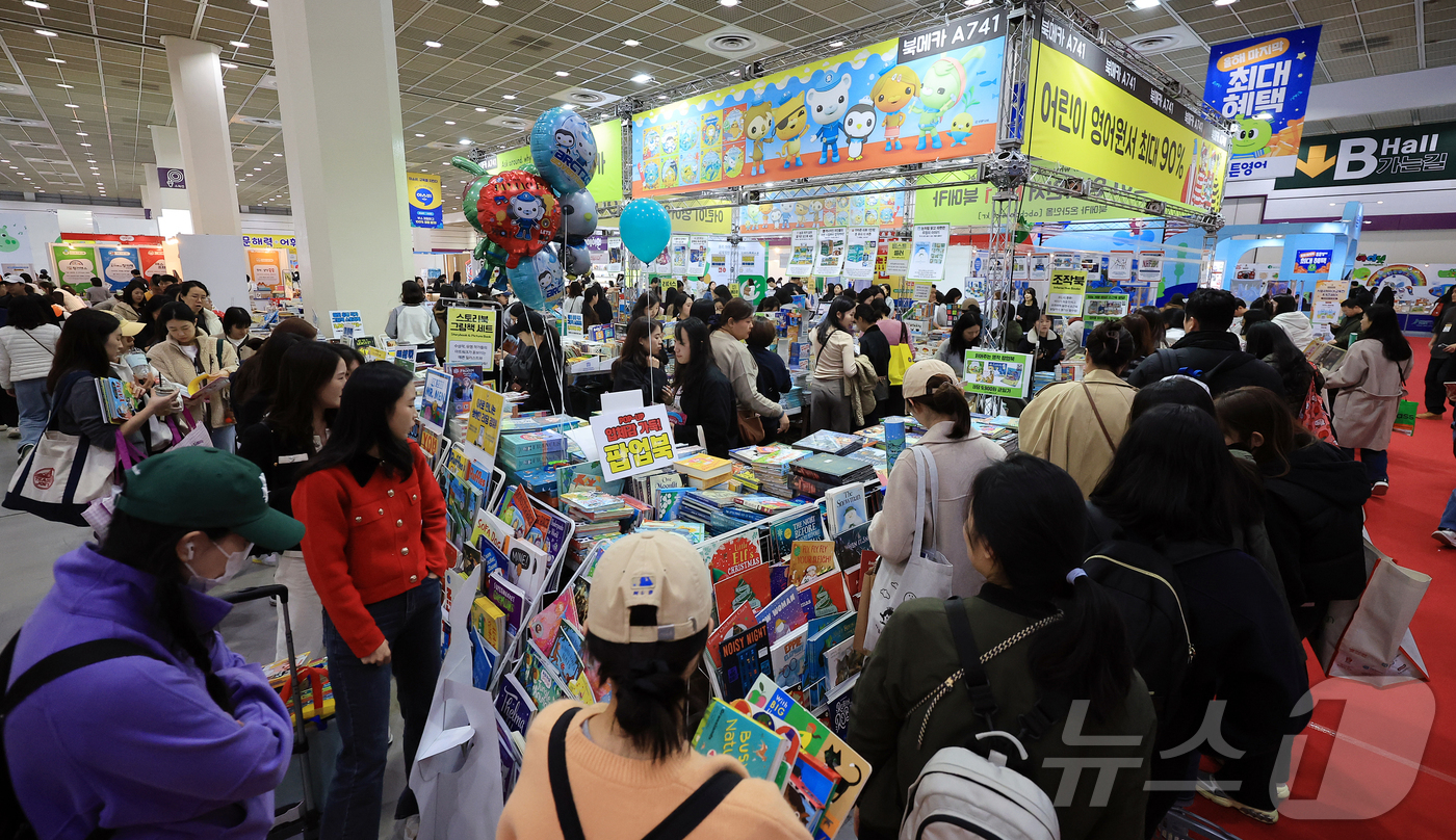(서울=뉴스1) 김진환 기자 = 13일 오후 서울 강남구 코엑스에서 열린 제56회 서울국제유아교육전 및 키즈페어를 찾은 관람객들이 책을 살펴보고 있다. 2025.11.13/뉴스1