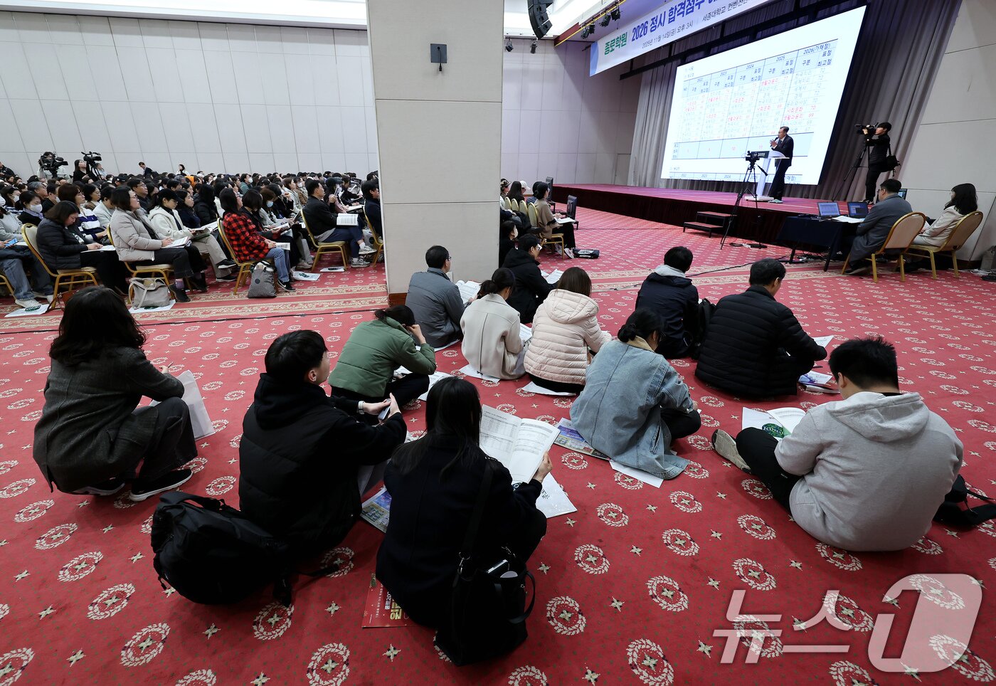 본문 이미지 - 14일 오후 서울 광진구 세종대에서 열린 종로학원 2026학년도 수능점수 분석 및 정시 합격점수예측 긴급설명회를 찾은 학부모들이 자리가 부족하자 바닥에 앉은 채 입시 전략에 대한 설명을 듣고 있다. 2025.11.14/뉴스1 ⓒ News1 장수영 기자