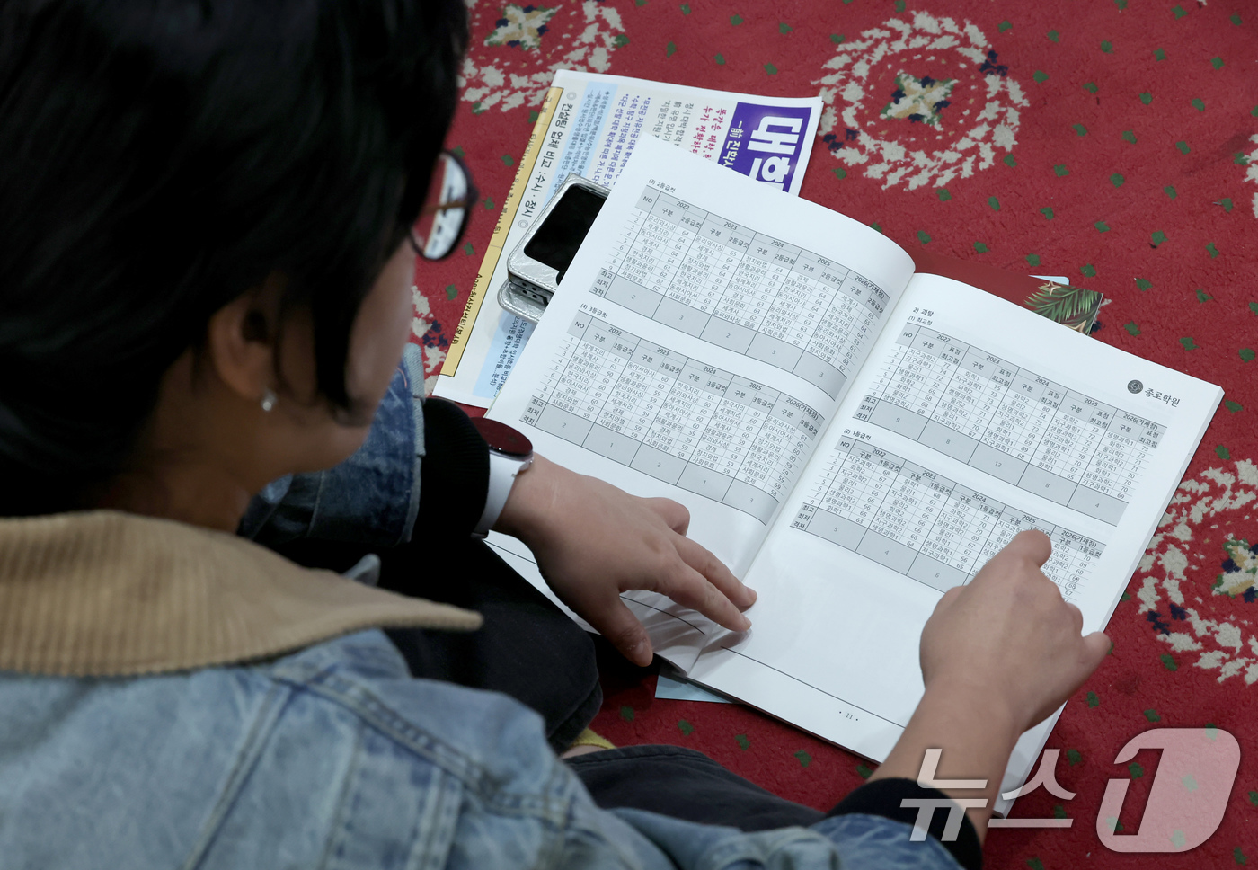 (서울=뉴스1) 장수영 기자 = 14일 오후 서울 광진구 세종대에서 열린 종로학원 2026학년도 수능점수 분석 및 정시 합격점수예측 긴급설명회를 찾은 학부모가 자리가 부족하자 바닥 …