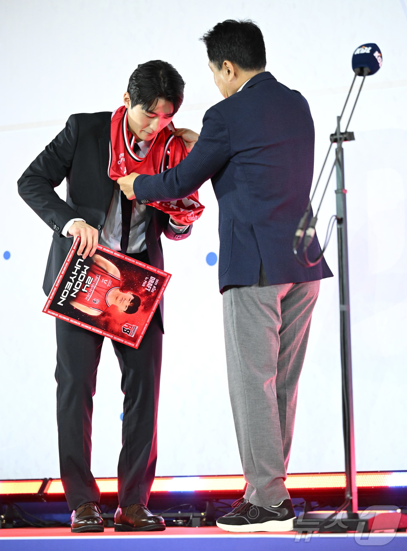 (서울=뉴스1) = 14일 오후 서울 송파구 잠실학생체육관에서 열린 2025 KBL 신인선수 드래프트에서 1라운드 1순위로 안양 정관장의 지명을 받은 문유현이 유도훈 감독의 도움으 …