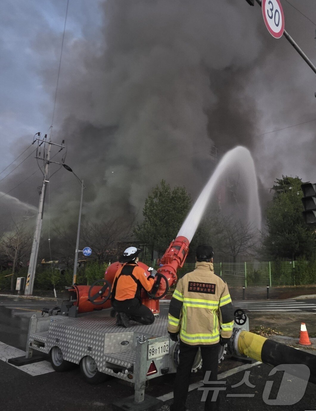 본문 이미지 - 15일 천안 이랜드 물류센터 화재 진압을 위해 동원된 대용량 방사포가 화재 현장에 굵은 물줄기를 뿜어 내고 있다.  2025.11.15/뉴스1 ⓒ News1 이시우 기자