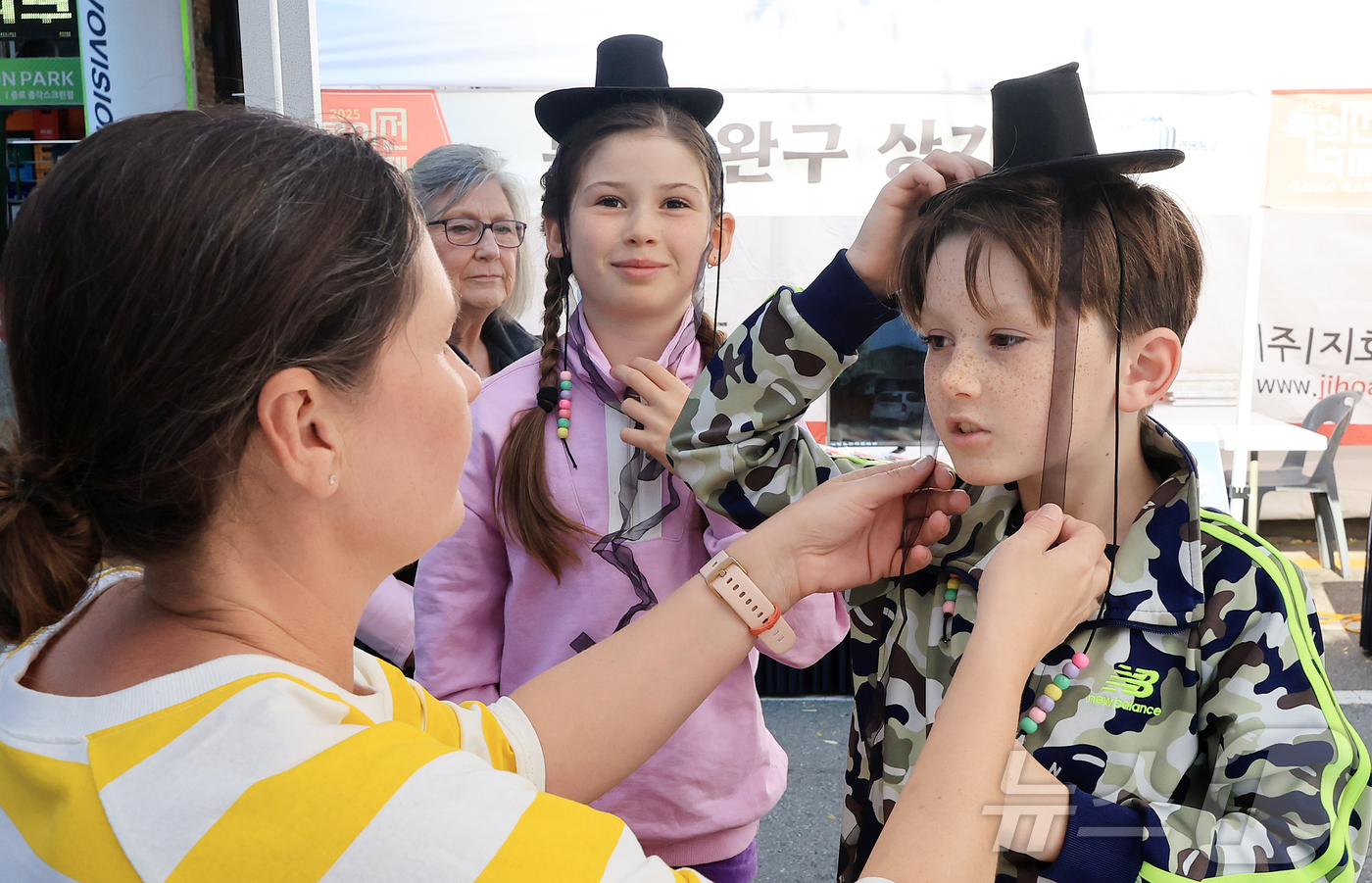 (서울=뉴스1) 김진환 기자 = 15일 오후 서울 종로구 청계천 장통교 일원에서 열린 '2025 육의전 축제'를 찾은 외국인 어린이들이 직접 만든 갓을 써보고 있다. 2025.11 …