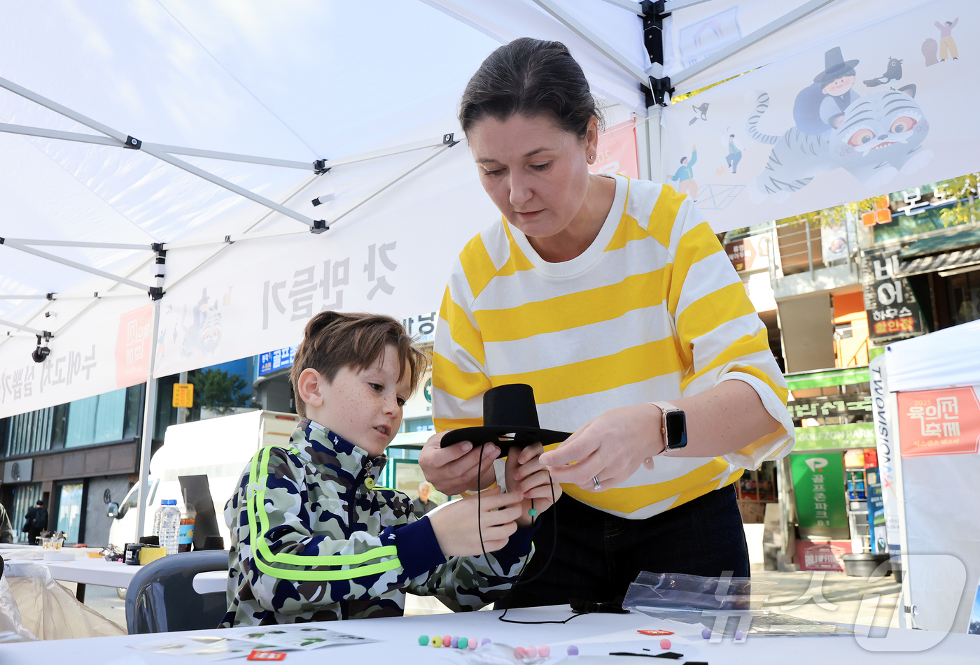 (서울=뉴스1) 김진환 기자 = 15일 오후 서울 종로구 청계천 장통교 일원에서 열린 '2025 육의전 축제'를 찾은 한 외국인 가족이 갓 만들기 체험을 하고 있다. 2025.11 …