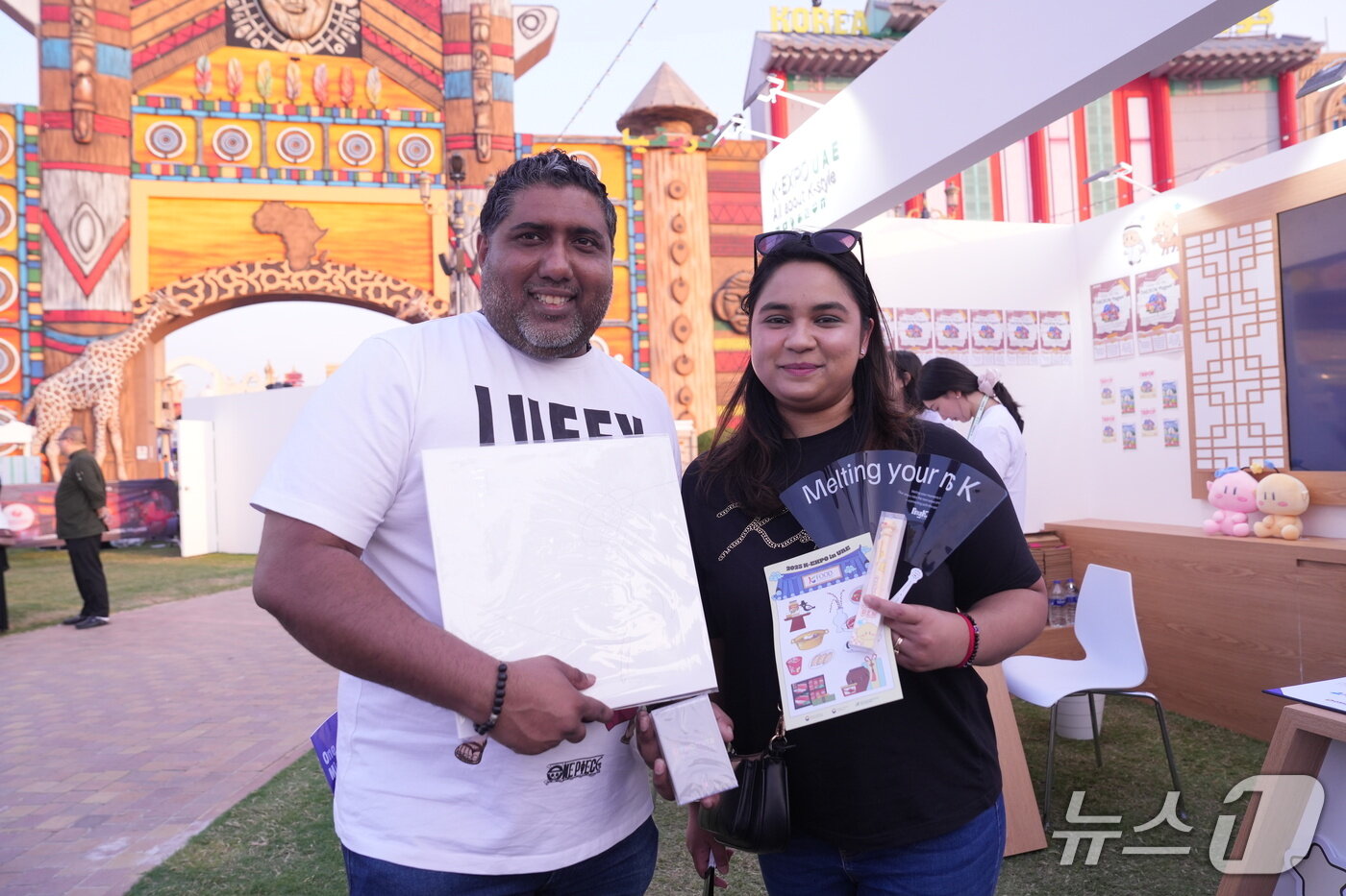 본문 이미지 - 남아프리카공화국에서 온 우간드라&#40;왼쪽&#41;·켈리샤 씨 부부가 K-엑스포 굿즈를 들고 있다.&#40;사진=이민혜&#41; 2025.11.15/뉴스1 ⓒ News1