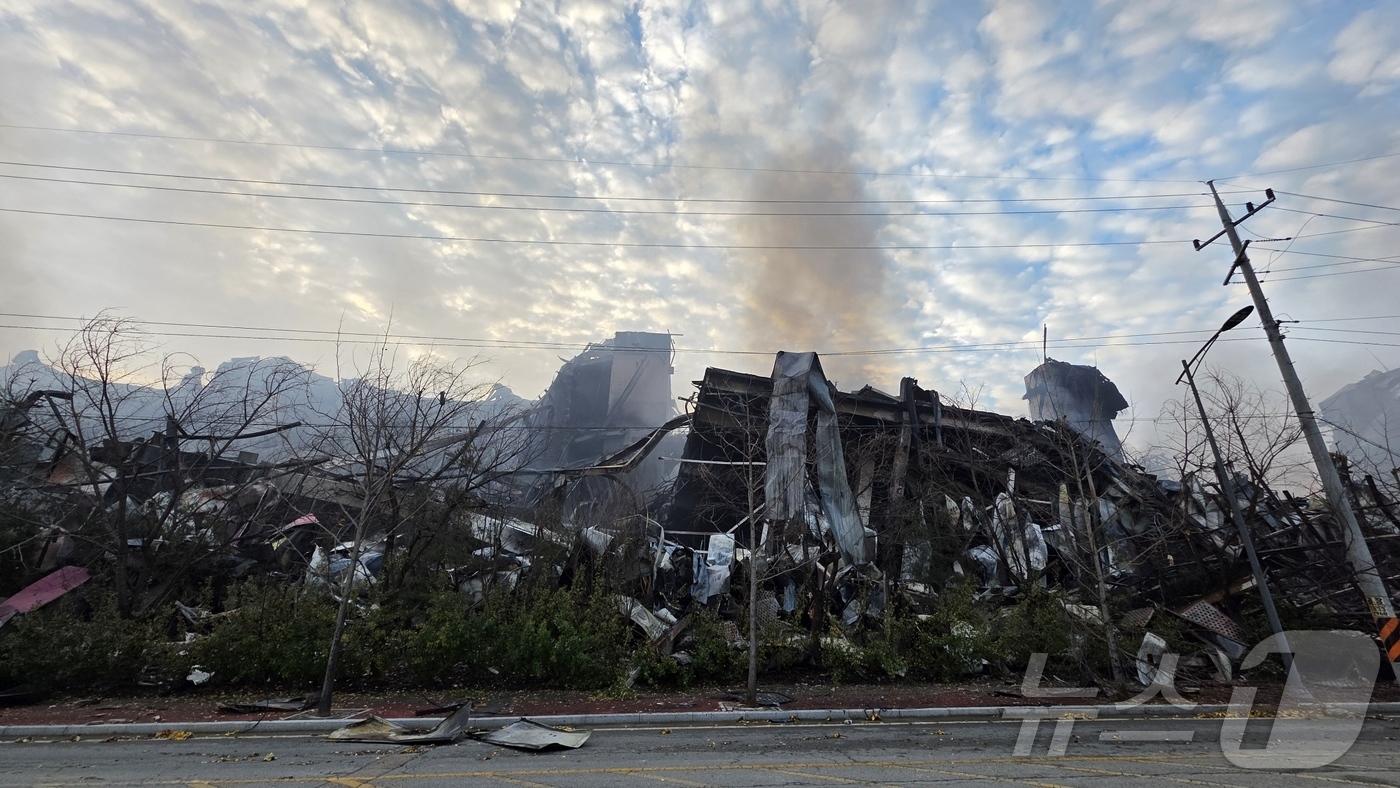 (천안=뉴스1) 이시우 기자 = 이랜드 물류창고 화재 이틀 째인 16일 충남 천안 동남구 이랜드패션 물류센터 창고 북측이 화마를 견디지 못하고 무너져 있다. 소방당국은 대응1단계를 …