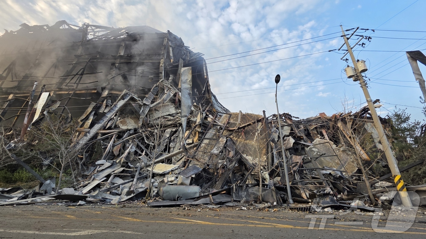 (천안=뉴스1) 이시우 기자 = 이랜드 물류창고 화재 이틀 째인 16일 충남 천안 동남구 이랜드패션 물류센터 창고 북측이 화마를 견디지 못하고 무너져 있다. 소방당국은 대응1단계를 …