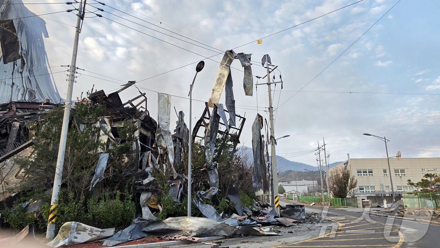 본문 이미지 - 이랜드 물류창고 화재 이틀 째인 16일 충남 천안 동남구 이랜드패션 물류센터 주변 전깃줄에 창고에서 떨어져 나온 샌드위치 패널이 걸려 바람에 흔들리고 있다. 소방당국은 대응1단계를 유지한 채 화재 진압을 이어가고 있다. 2025.11.16/ 2025.11.16/뉴스1 ⓒ News1 이시우 기자