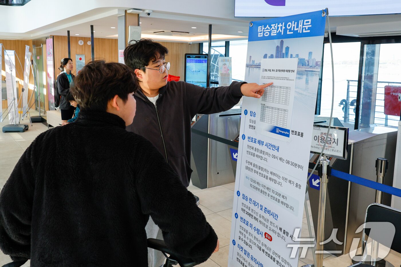 본문 이미지 - 16일 서울 송파구 한강버스 잠실선착장을 찾은 학생들이 잠실, 뚝섬, 옥수, 압구정선착장 미운항 안내문을 보고 있다.  2025.11.16/뉴스1 ⓒ News1 안은나 기자