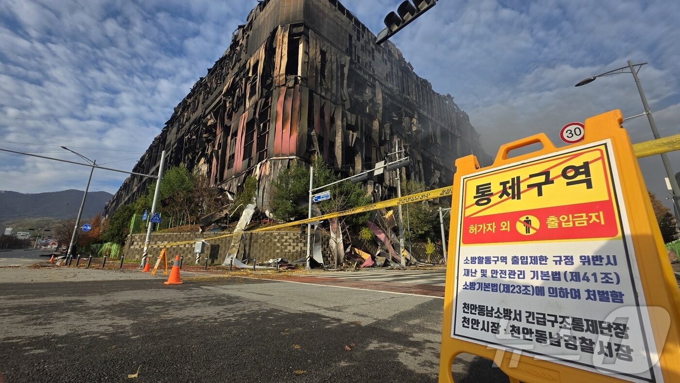 본문 이미지 - 충남 천안 동남구 이랜드패션 물류센터 화재 이틀 째인 16일 화재 현장 주변에 출입 금지 표지판이 설치돼 있다. 소방당국은 대응1단계를 유지한 채 화재 진압을 이어가고 있다. 2025.11.16/뉴스1 ⓒ News1 이시우 기자