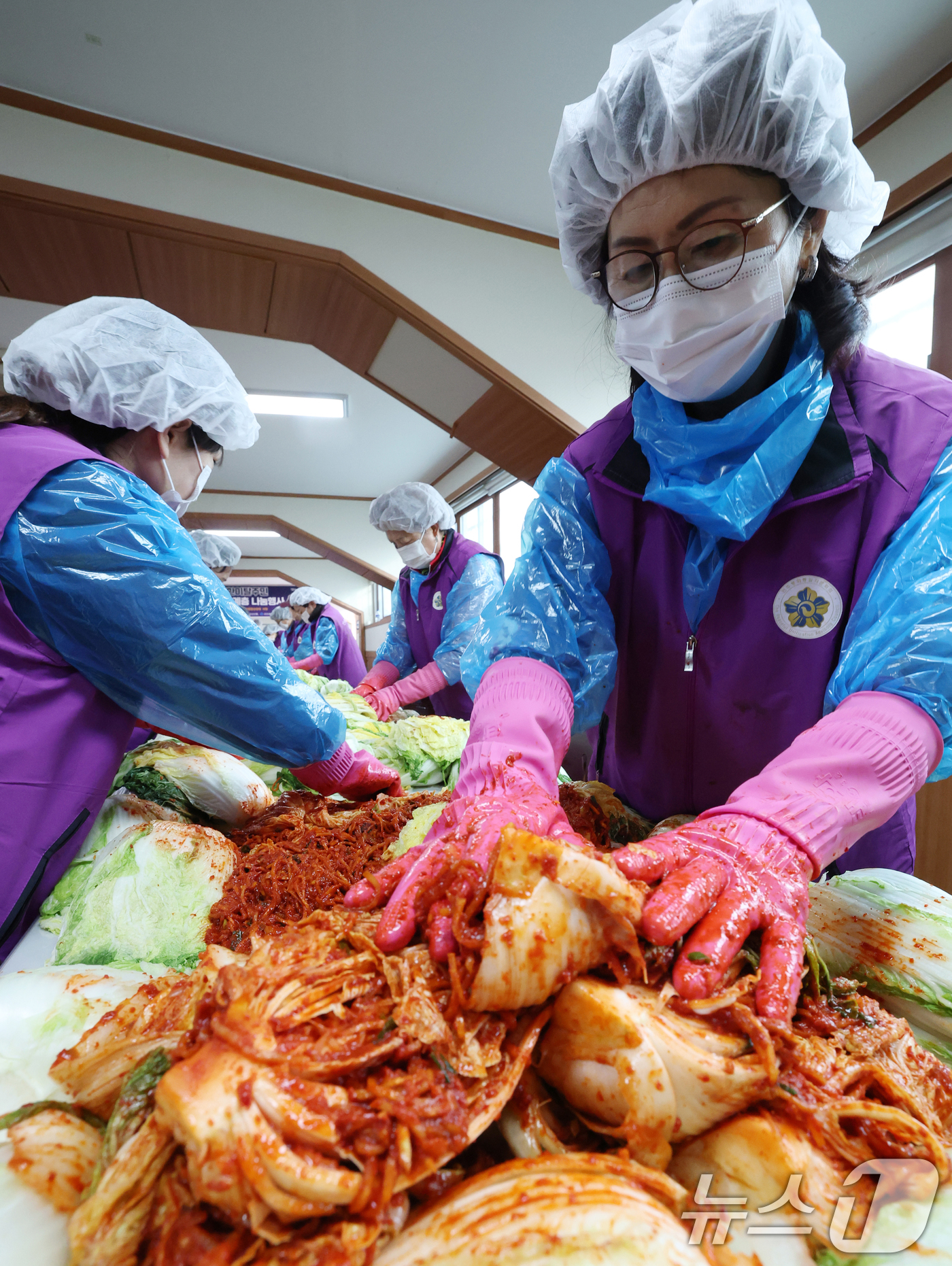 (오산=뉴스1) 김영운 기자 = 13일 경기 오산시 오산종합운동장에서 열린 '2025년 북한이탈주민 김장체험 및 소외계층 나눔행사'에서 자원봉사자들이 김치를 담그고 있다. 2025 …