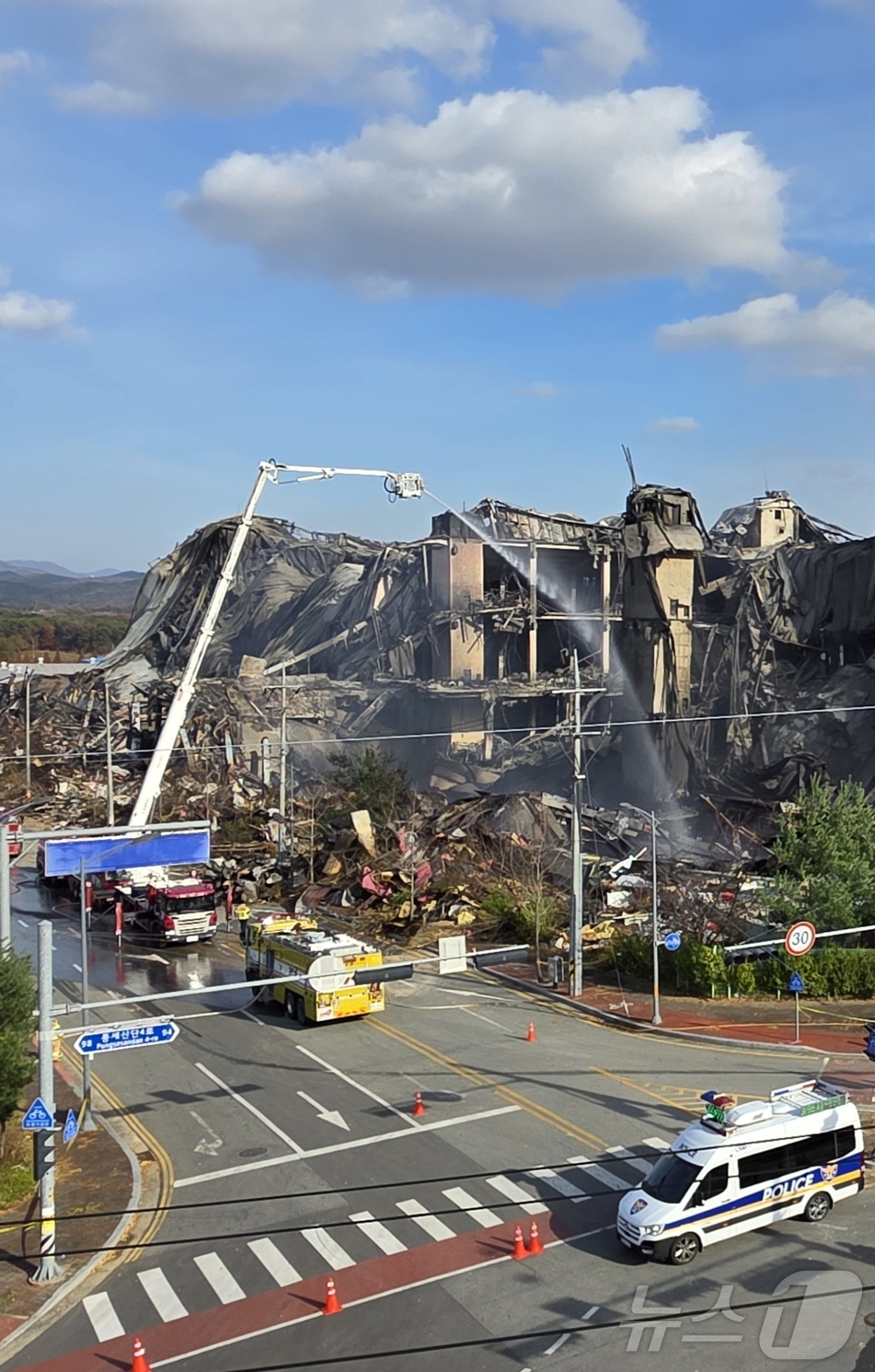 (천안=뉴스1) 이시우 기자 = 이랜드패션 물류센터 화재 사흘 째인 17일 충남 천안 동남구 화재현장에서 무너진 창고 위로 굴절 사다리차가 화재 진압을 하고 있다. 2025.11. …