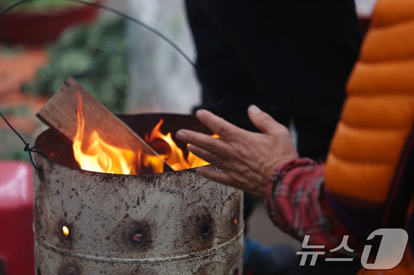 본문 이미지 - 광주 무등산 아침최저기온이 -3.3도를 기록한 18일 오전 광주 동구 남광주시장 상인들이 추위를 피하기 위해 불을 쬐고 있다. 2025.11.18/뉴스1 ⓒ News1 박지현 기자