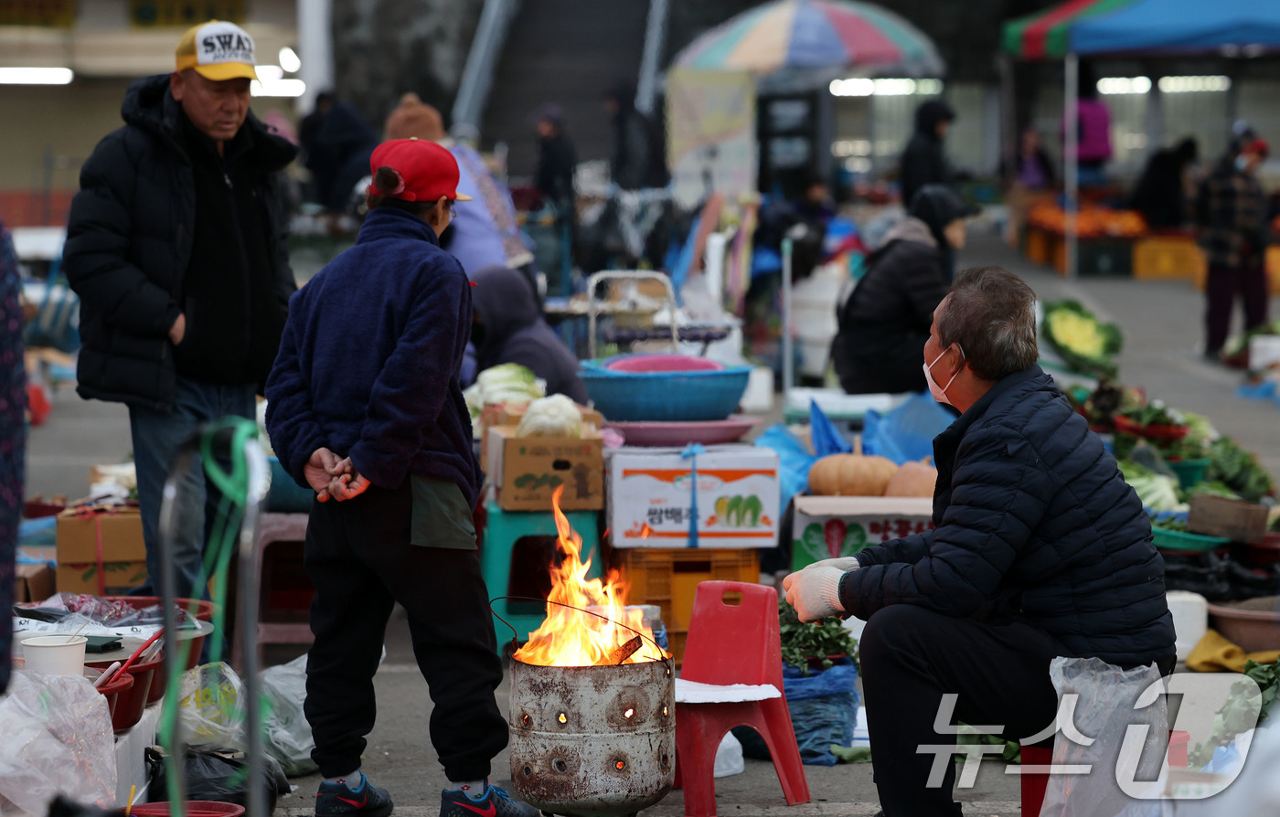 (광주=뉴스1) 박지현 기자 = 광주 무등산 아침최저기온이 -3.3도를 기록한 18일 오전 광주 동구 남광주시장 상인들이 추위를 피하기 위해 불을 쬐고 있다. 2025.11.18/ …