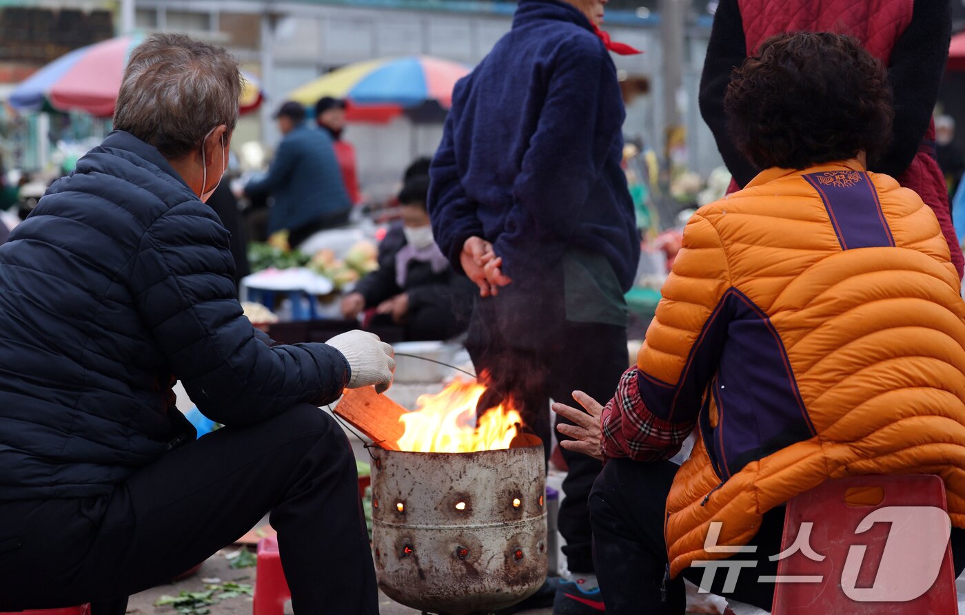 본문 이미지 - 광주 무등산 아침최저기온이 -3.3도를 기록한 18일 오전 광주 동구 남광주시장 상인들이 추위를 피하기 위해 불을 쬐고 있다. 2025.11.18/뉴스1 ⓒ News1 박지현 기자