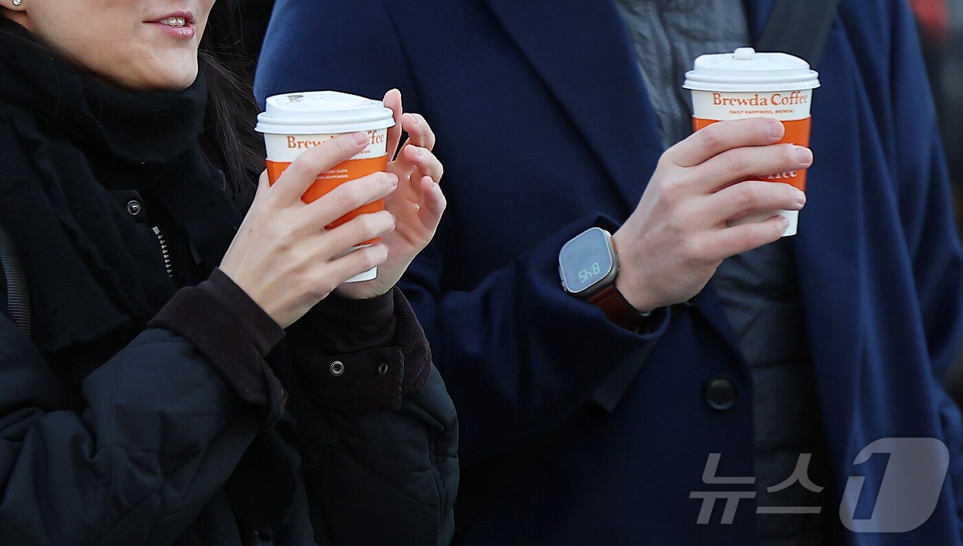 본문 이미지 - 아침 기온이 전날보다 5~10도 가량 큰 폭으로 떨어져 추운 날씨를 보인 18일 오전 서울 종로구 광화문네거리에서 두터운 옷차림을 시민들이 따뜻한 커피를 든 채 발걸음을 옮기고 있다. 2025.11.18/뉴스1 ⓒ News1 김진환 기자